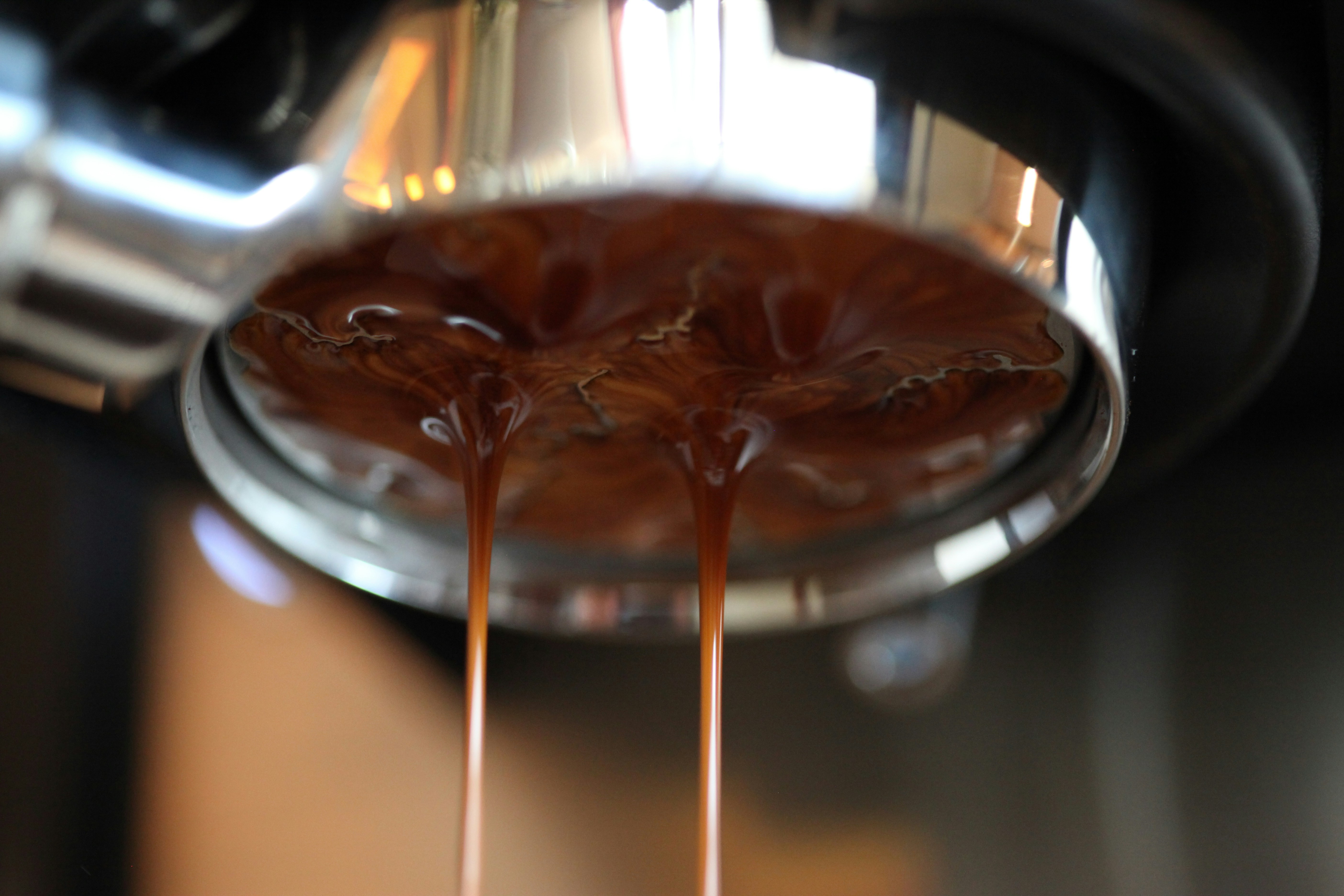 Espresso pouring from a coffee machine portafilter.