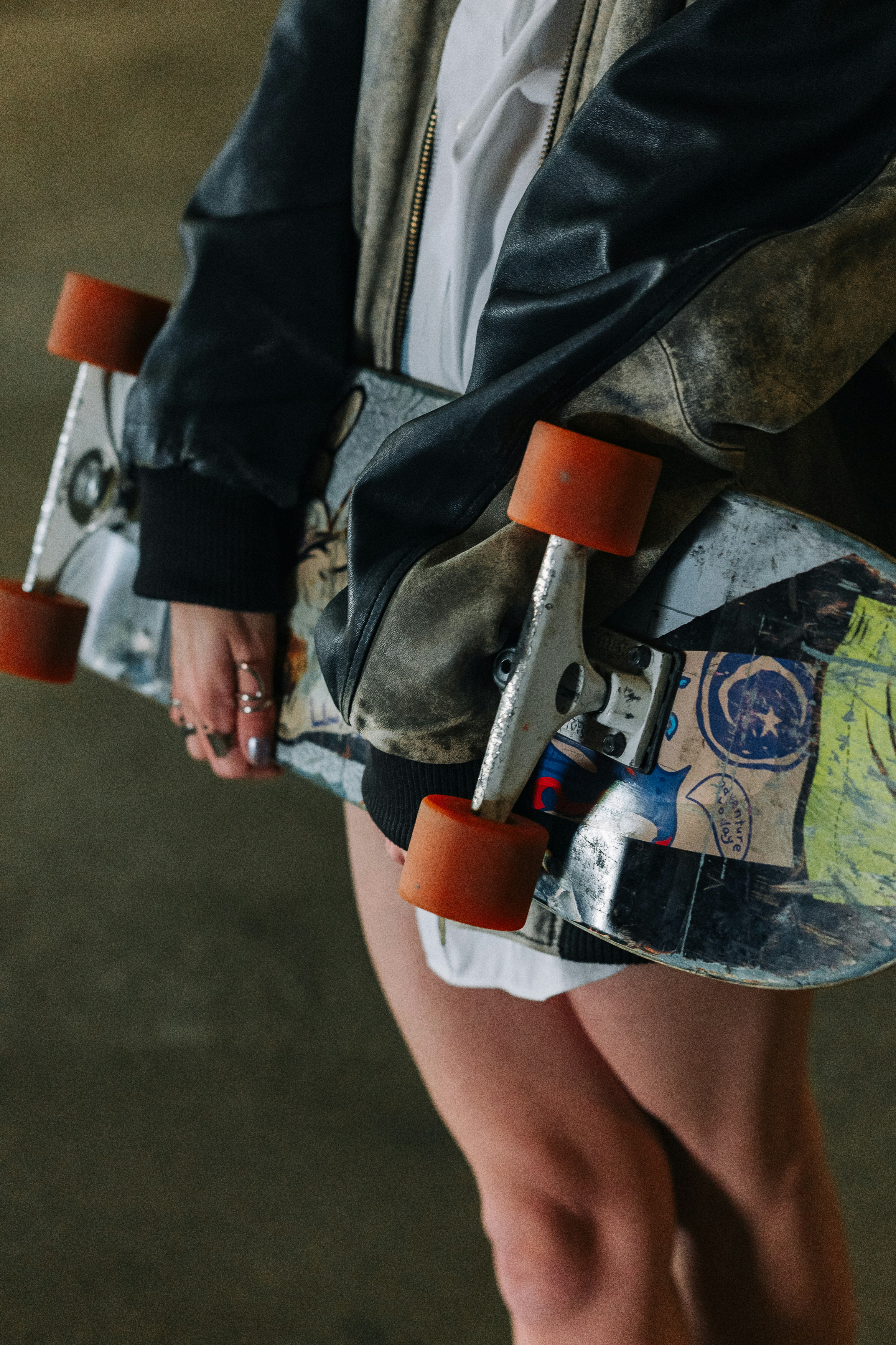 Personne tenant un skateboard avec des roues orange