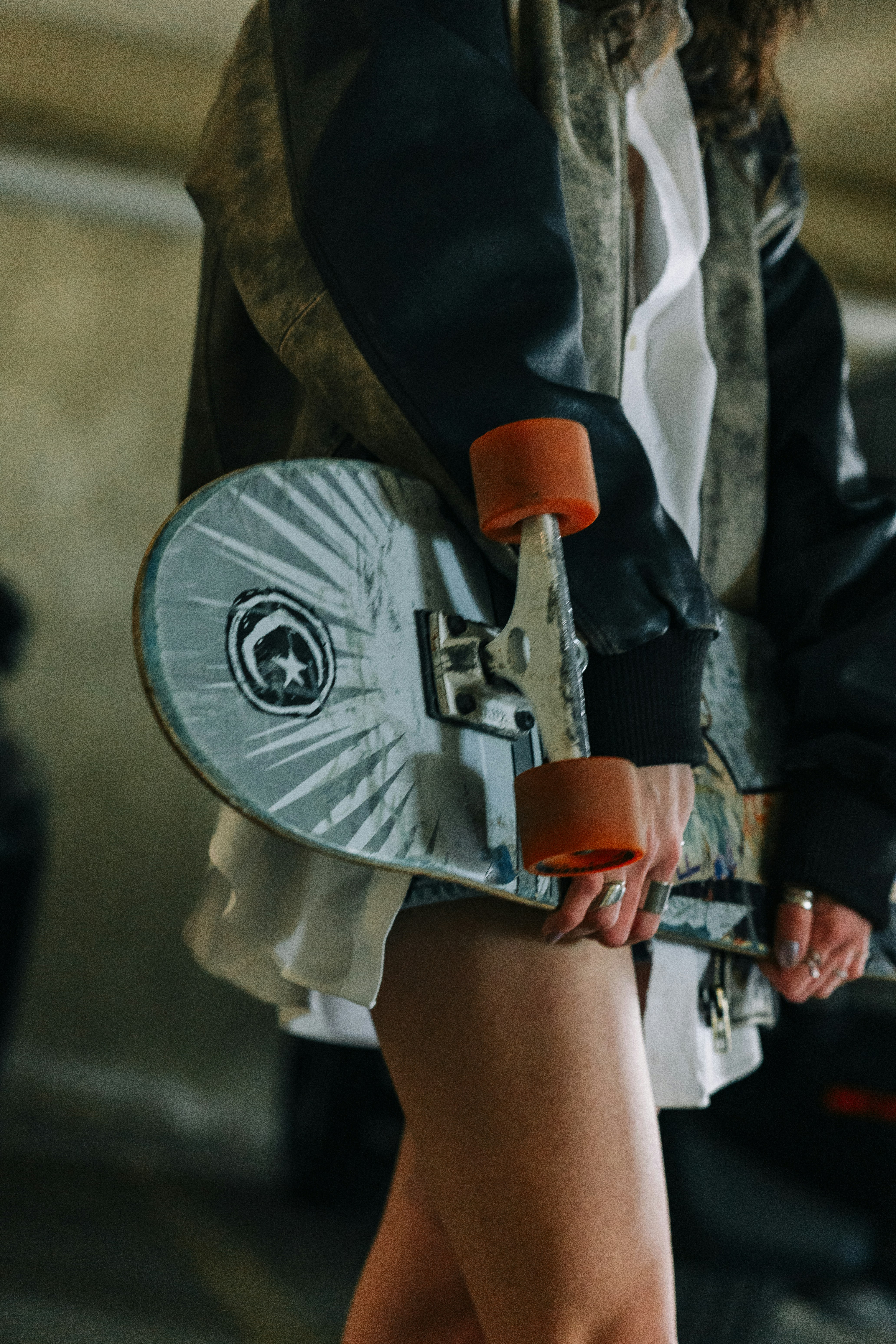 Personne tenant un skateboard avec des roues orange