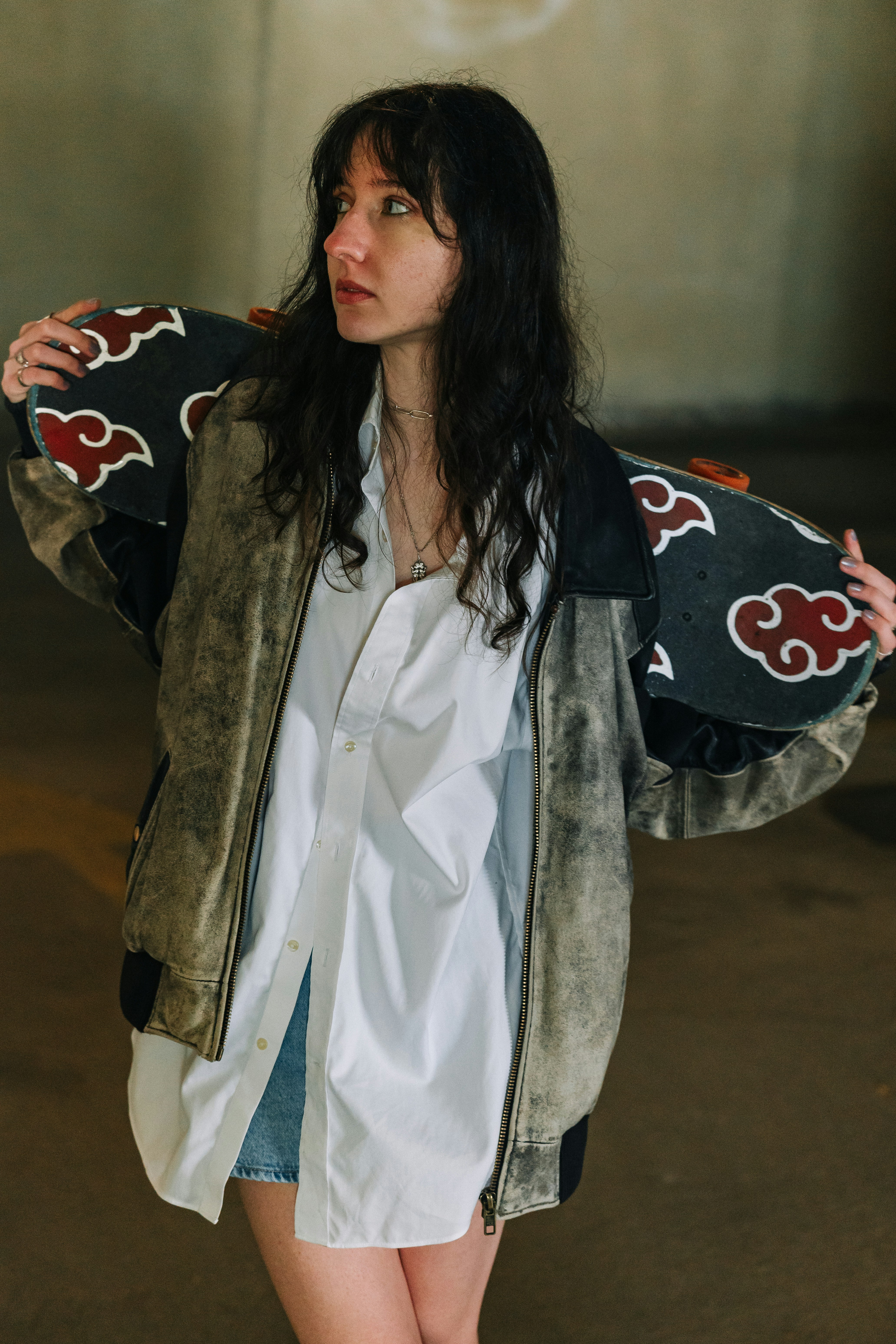Jeune femme aux cheveux foncés tenant un skateboard