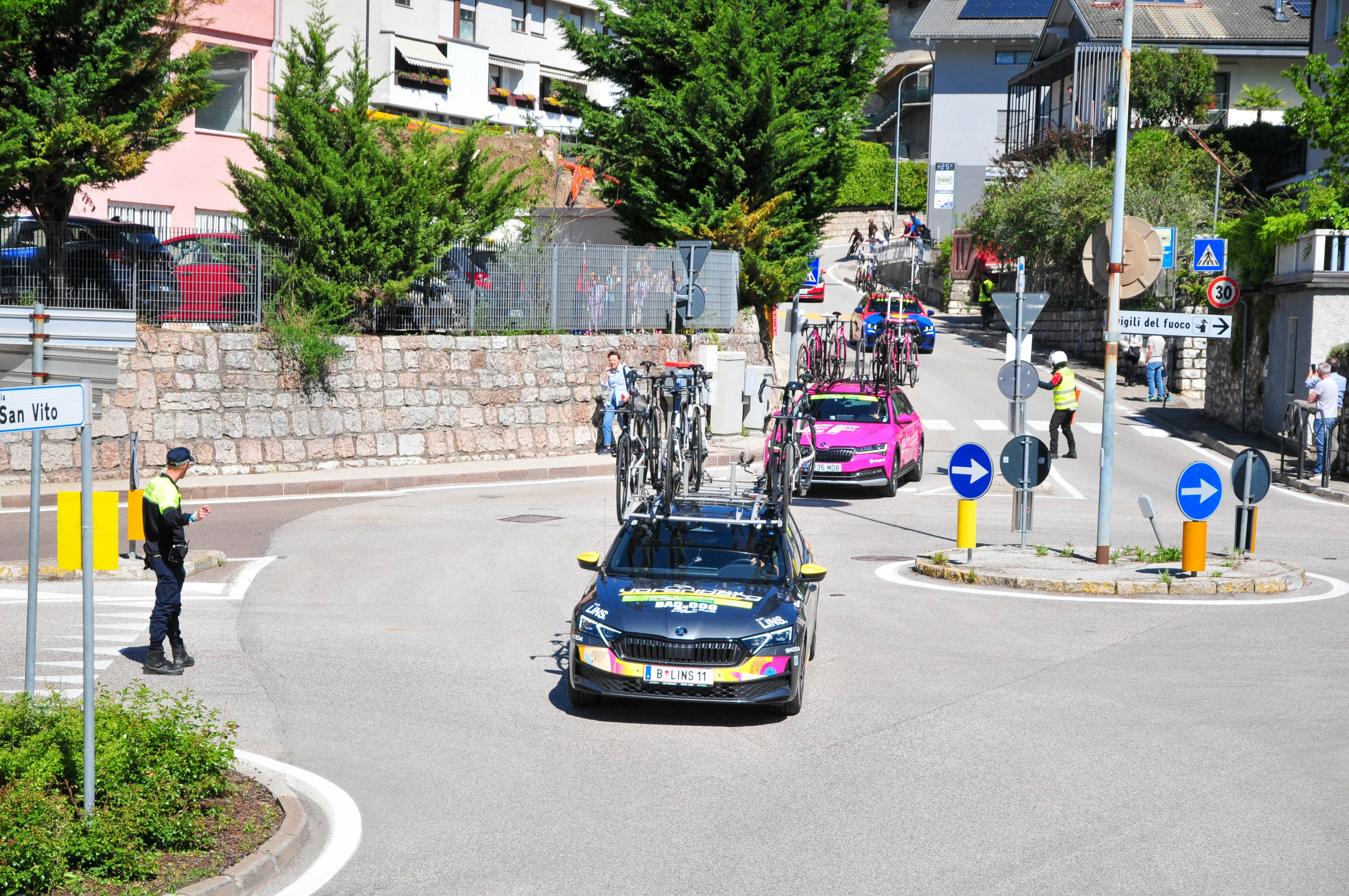 Cycling race caravan with support cars and cyclists