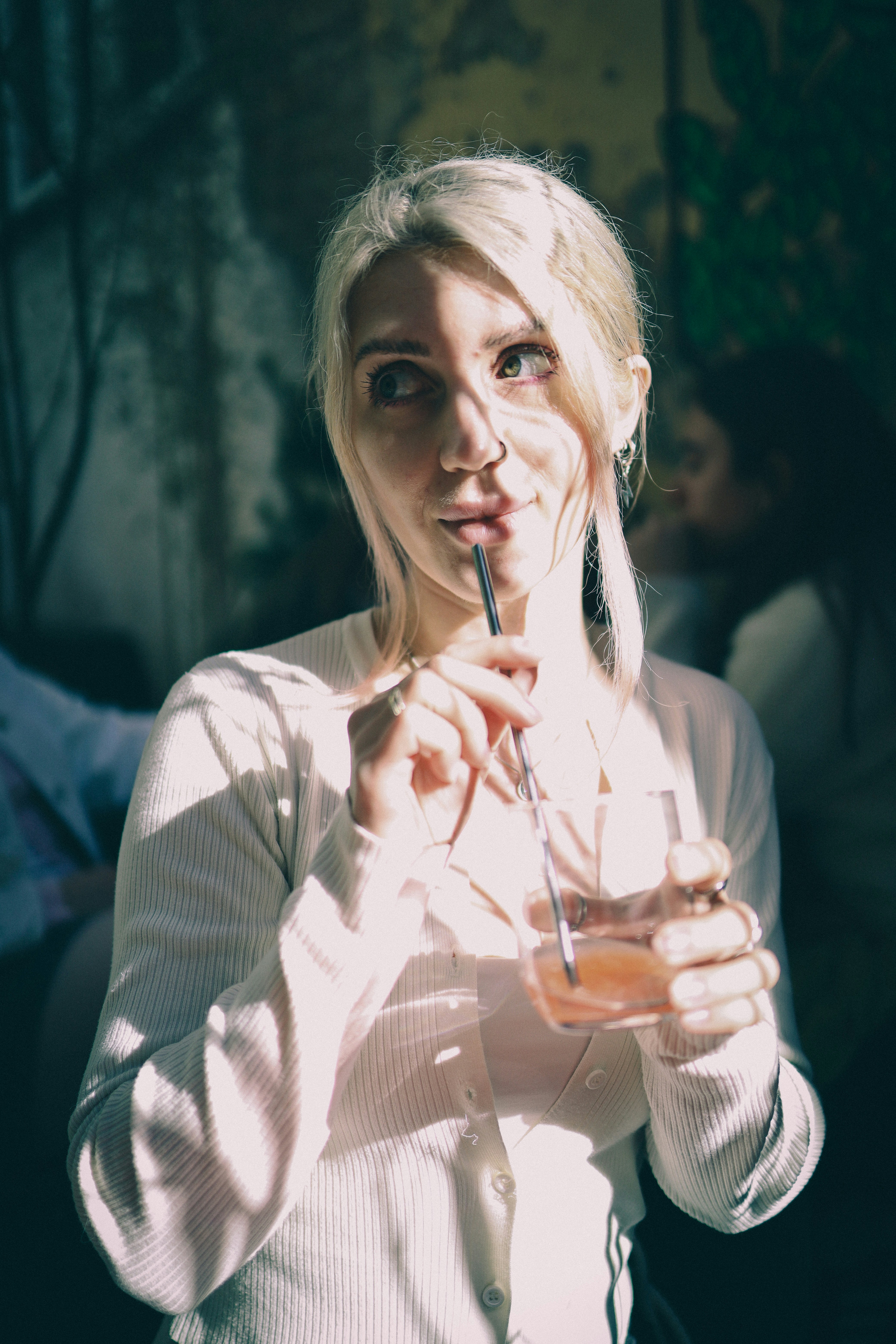 Young woman with blonde hair drinking a beverage