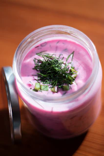 Pink soup with dill and green onions in a jar