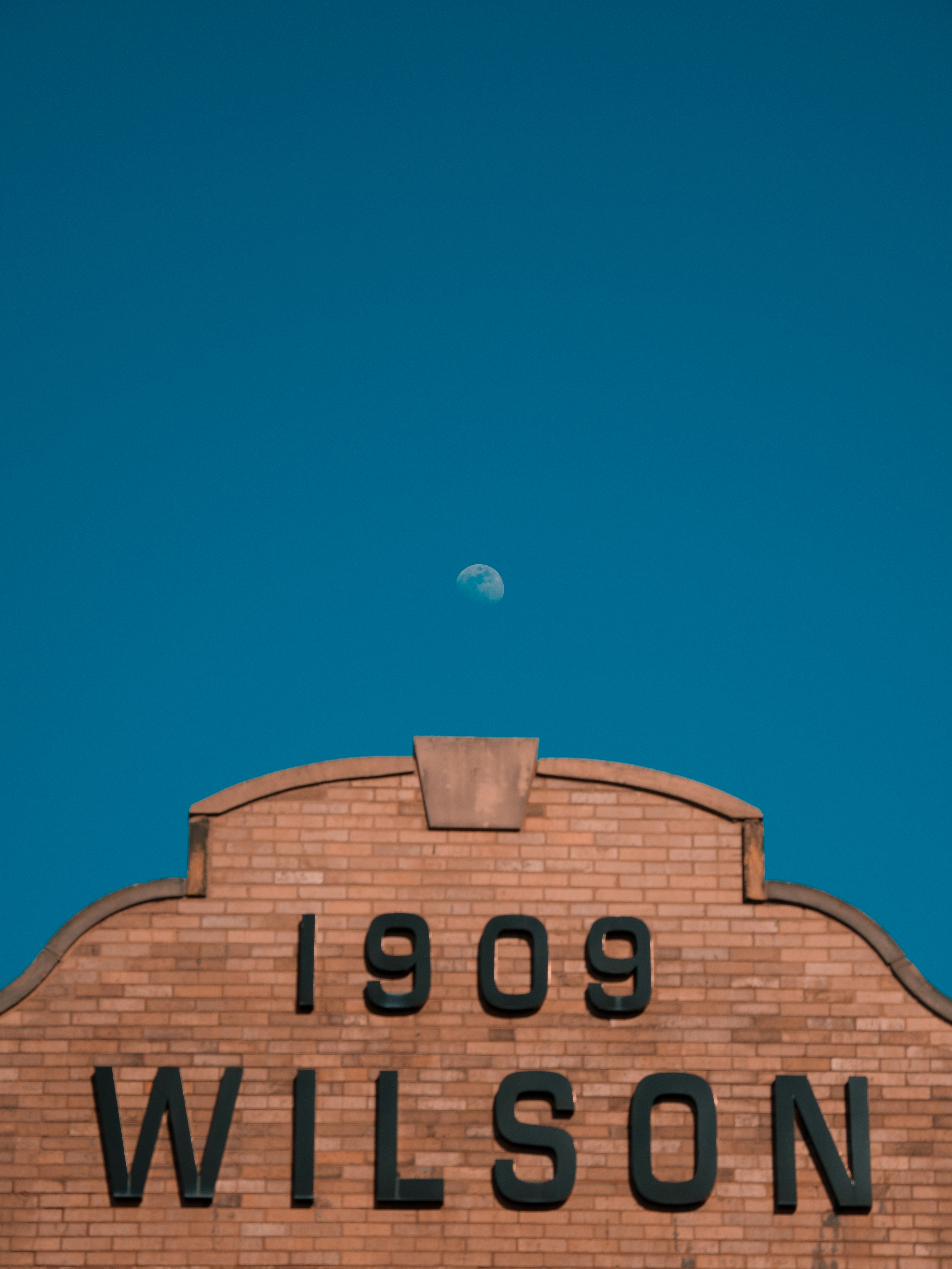 Brick building facade with "1909 wilson" and moon.