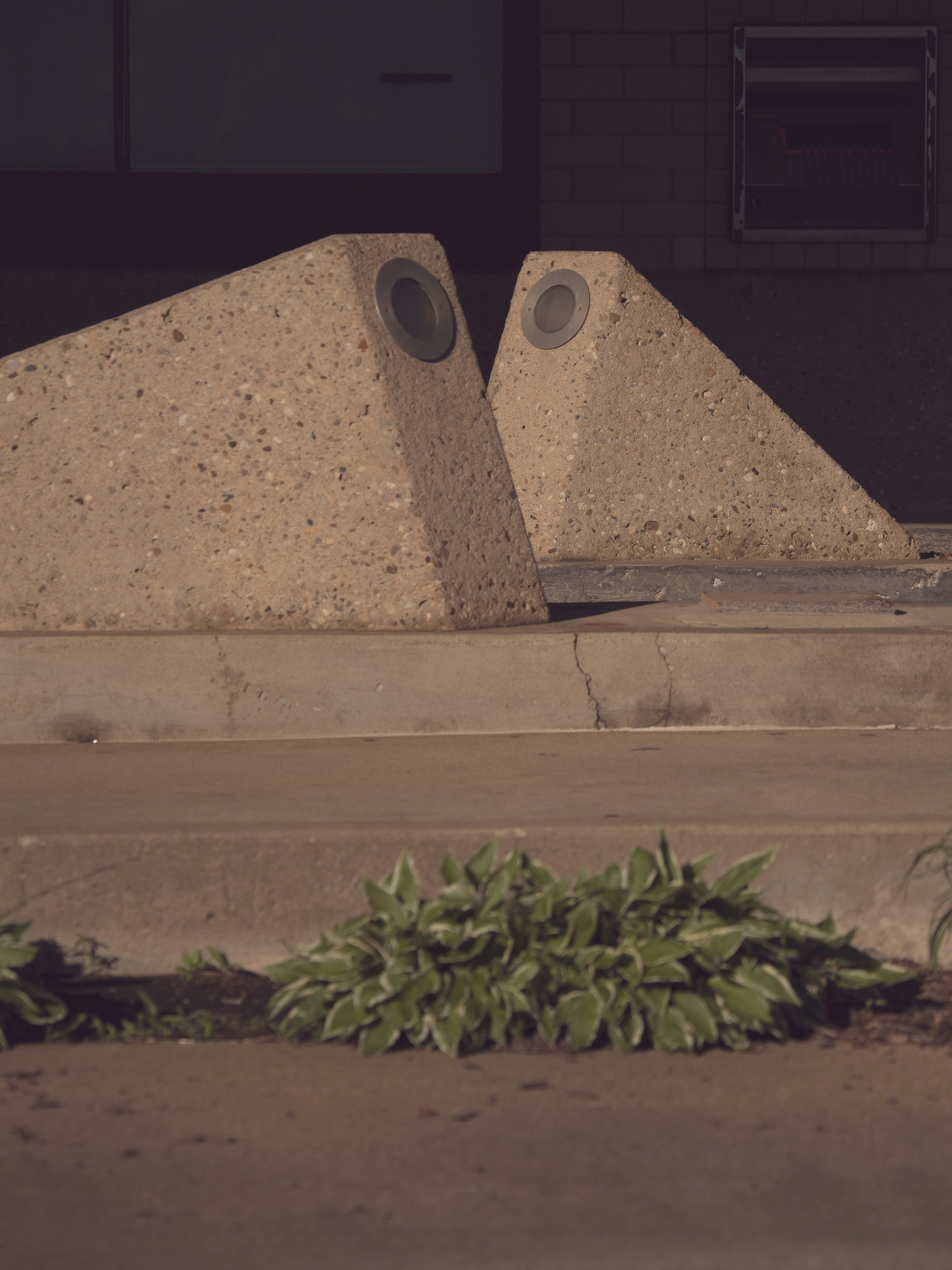 Two concrete bollards with circular indentations.