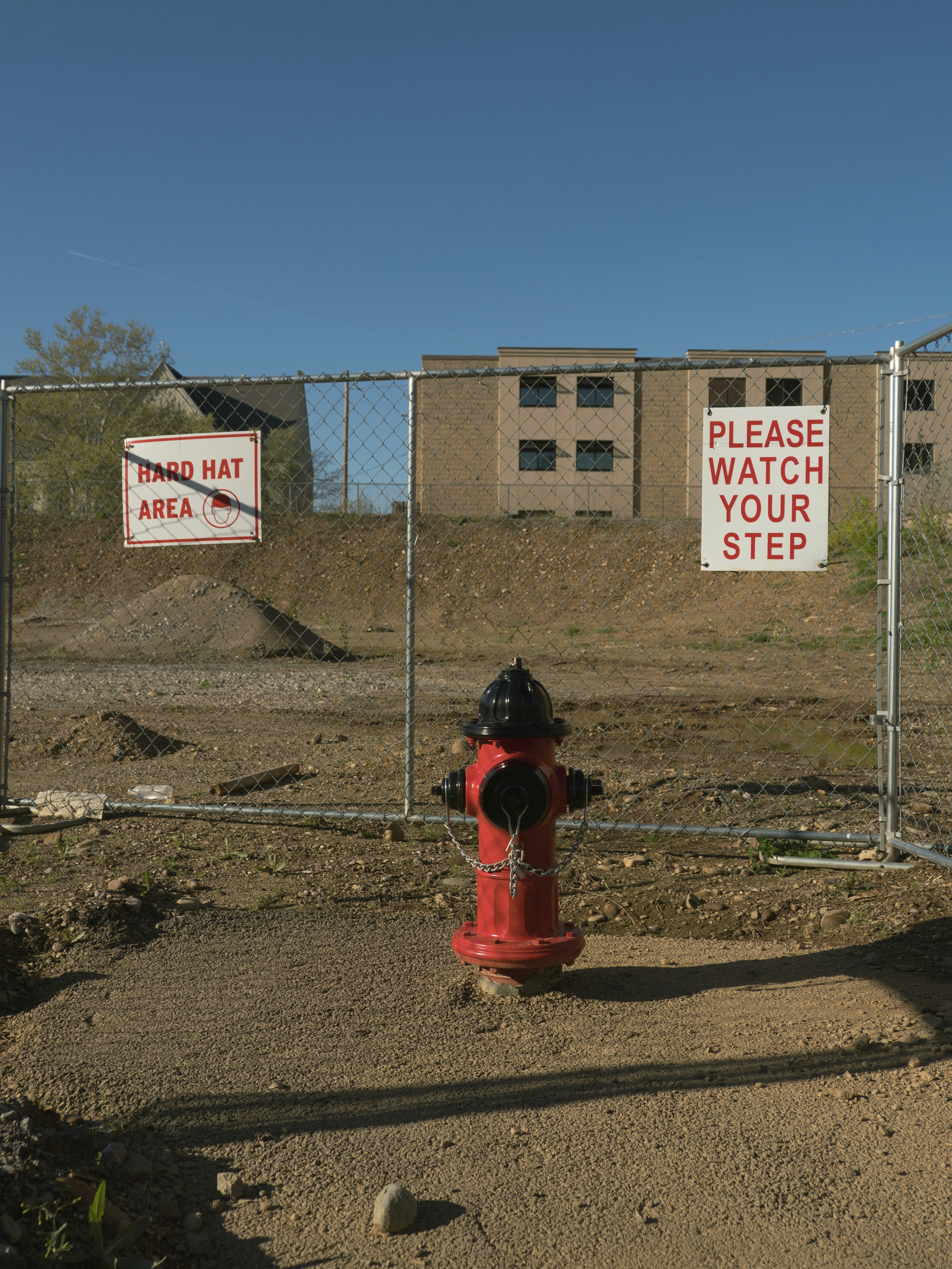 Red fire hydrant behind a chain-link fence