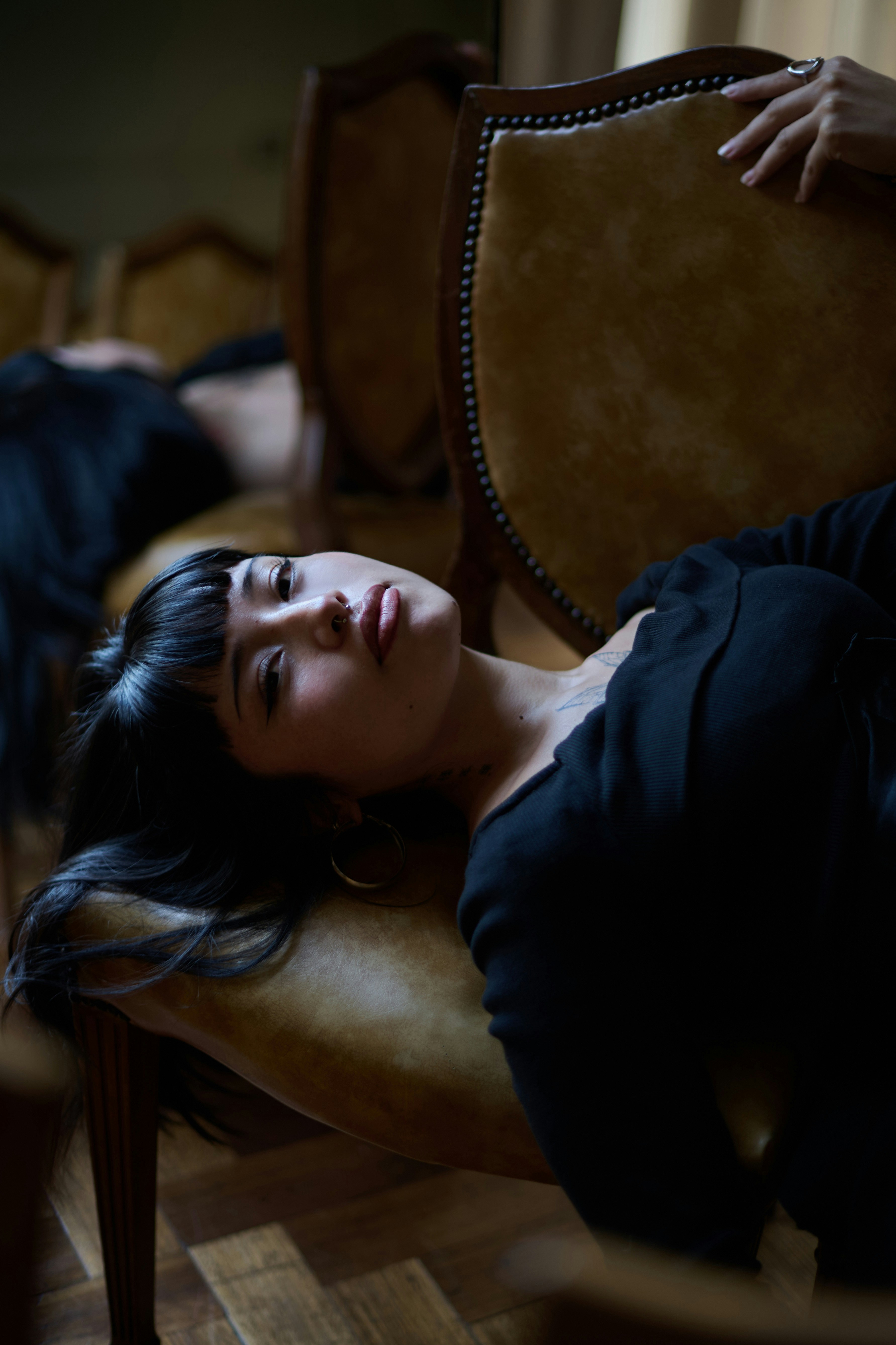 Woman lying on a vintage chair with hand raised