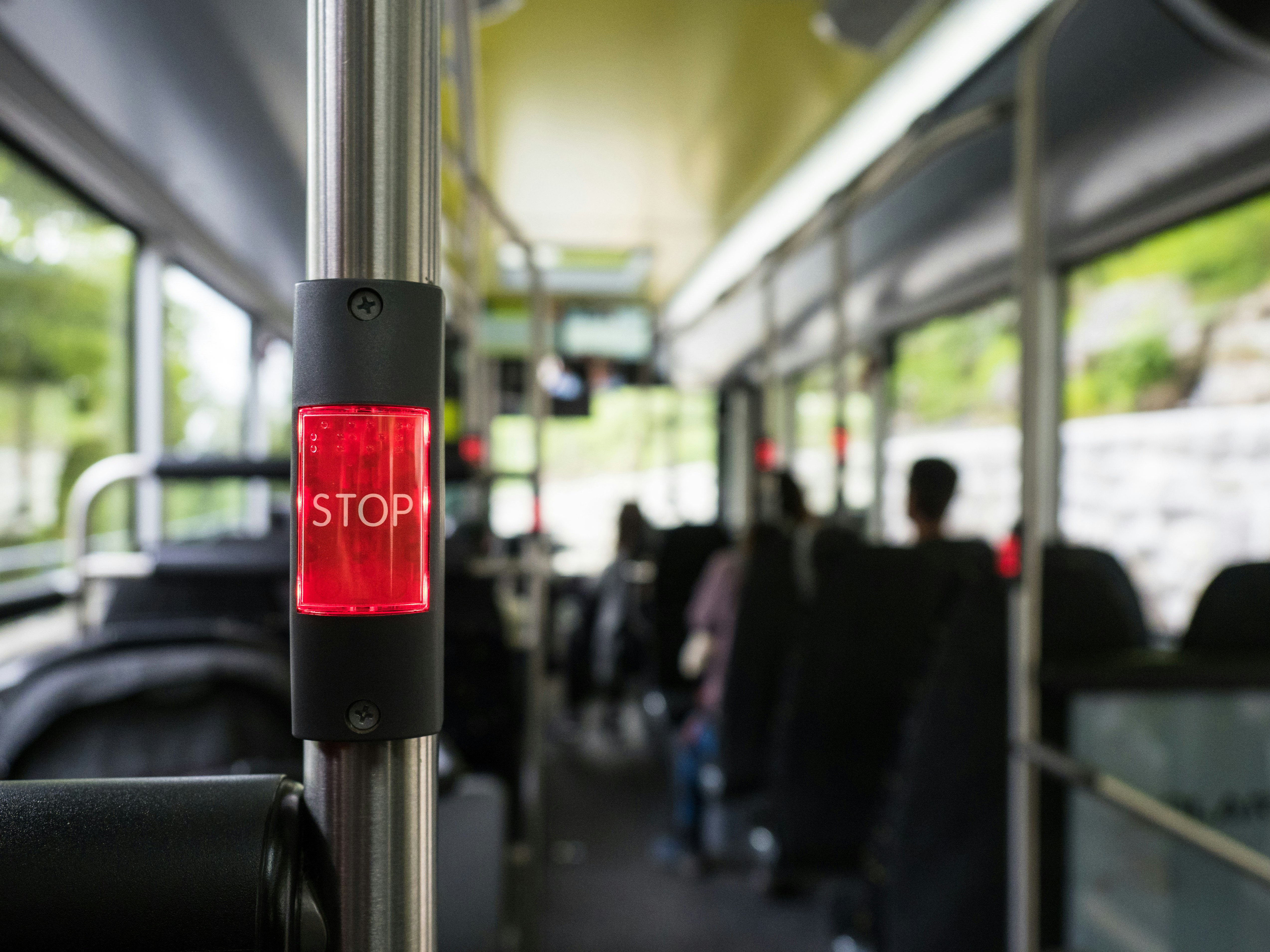 Red stop button illuminated inside a bus.