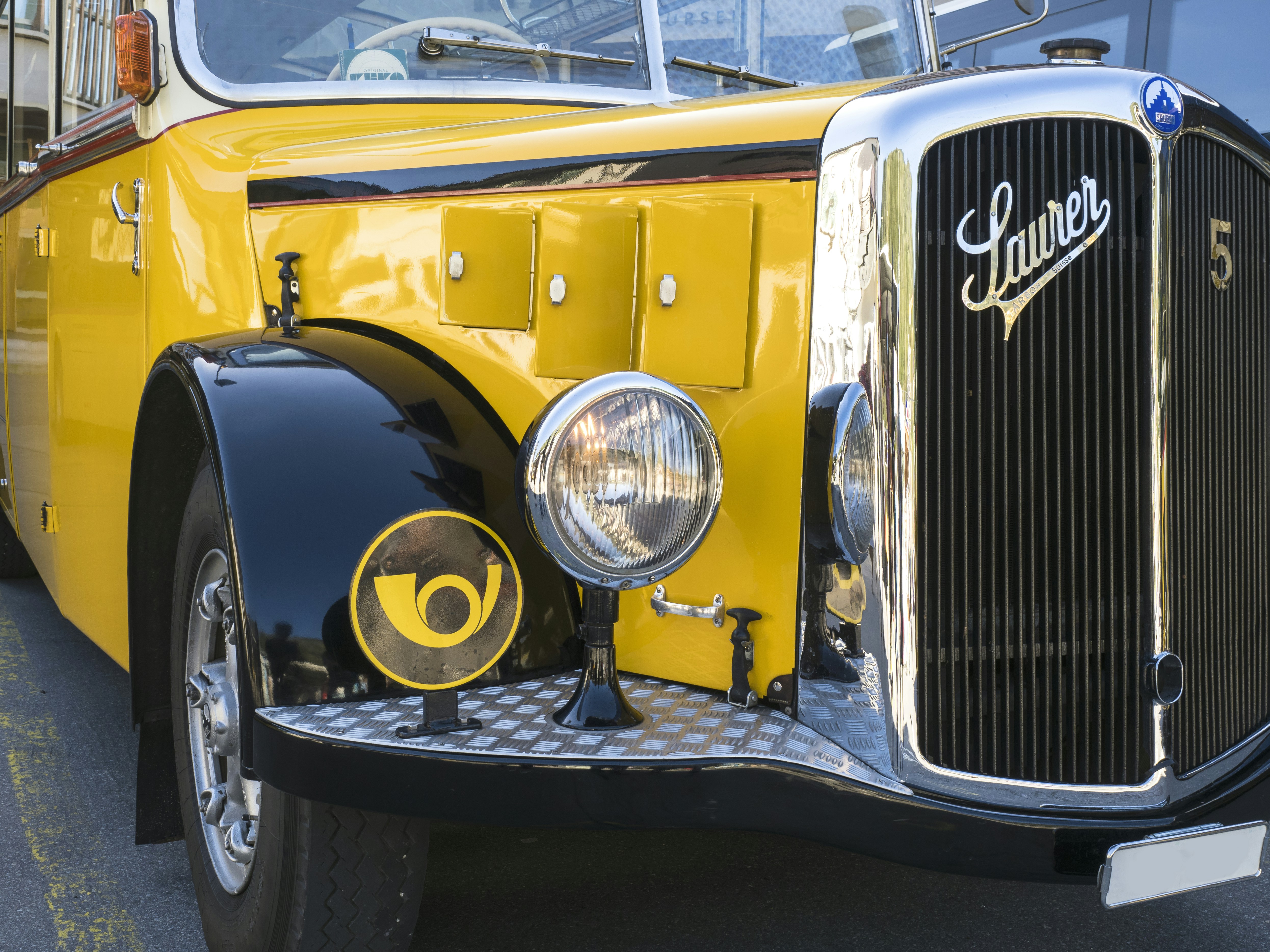Vintage yellow bus with a chrome grille and headlights