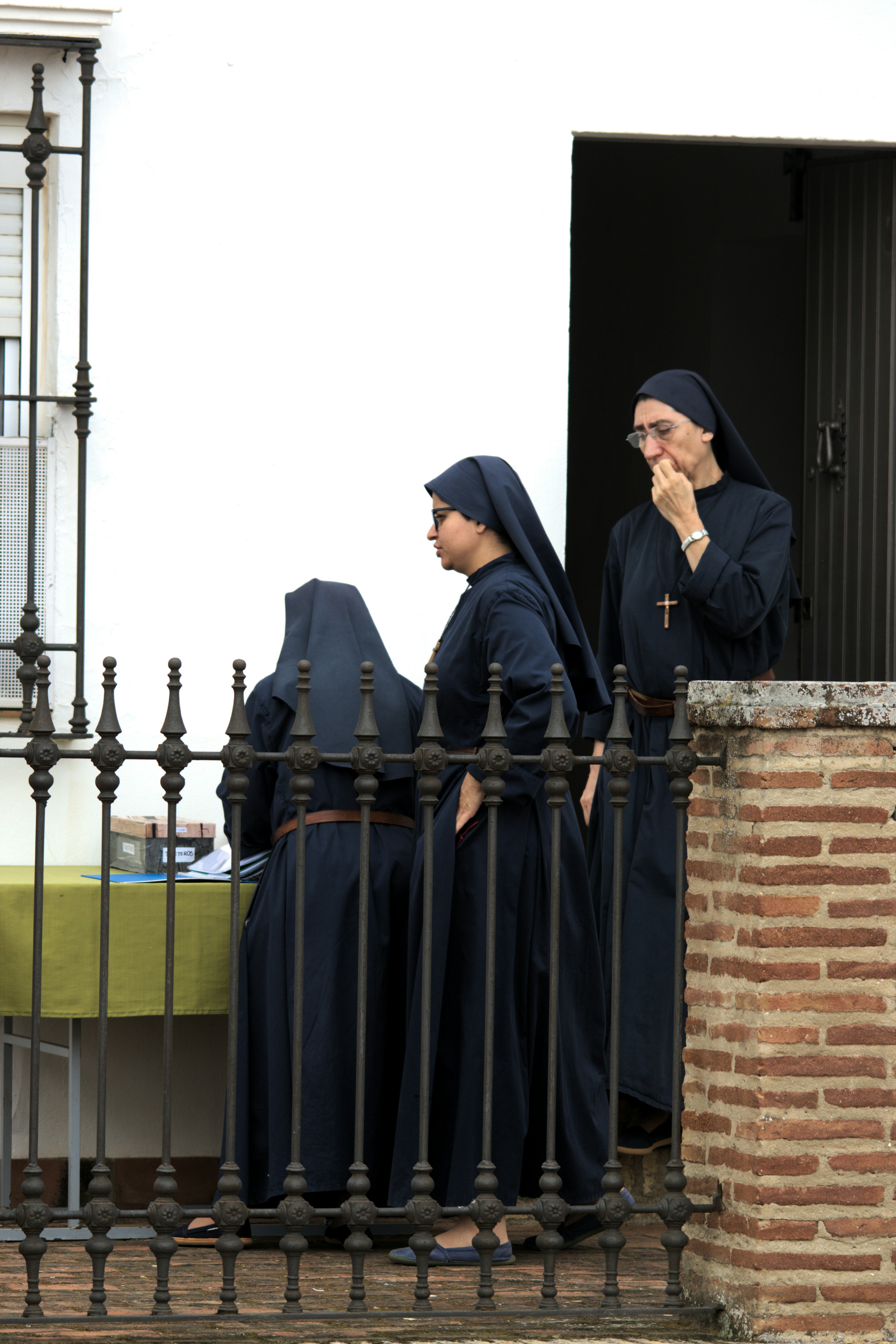 Three nuns in dark habits standing together.