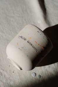 A white mug with 'slow morning' written on it.