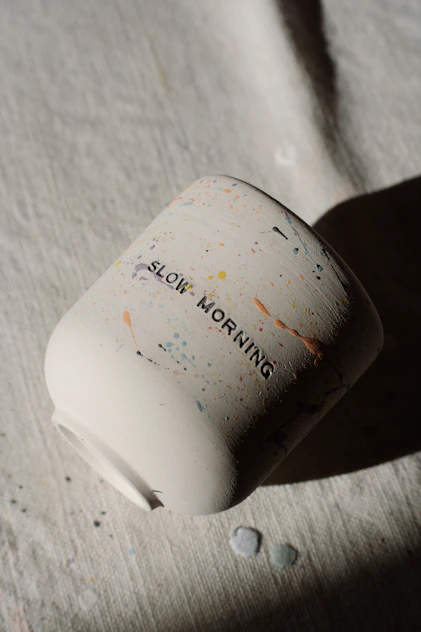 A white mug with 'slow morning' written on it.