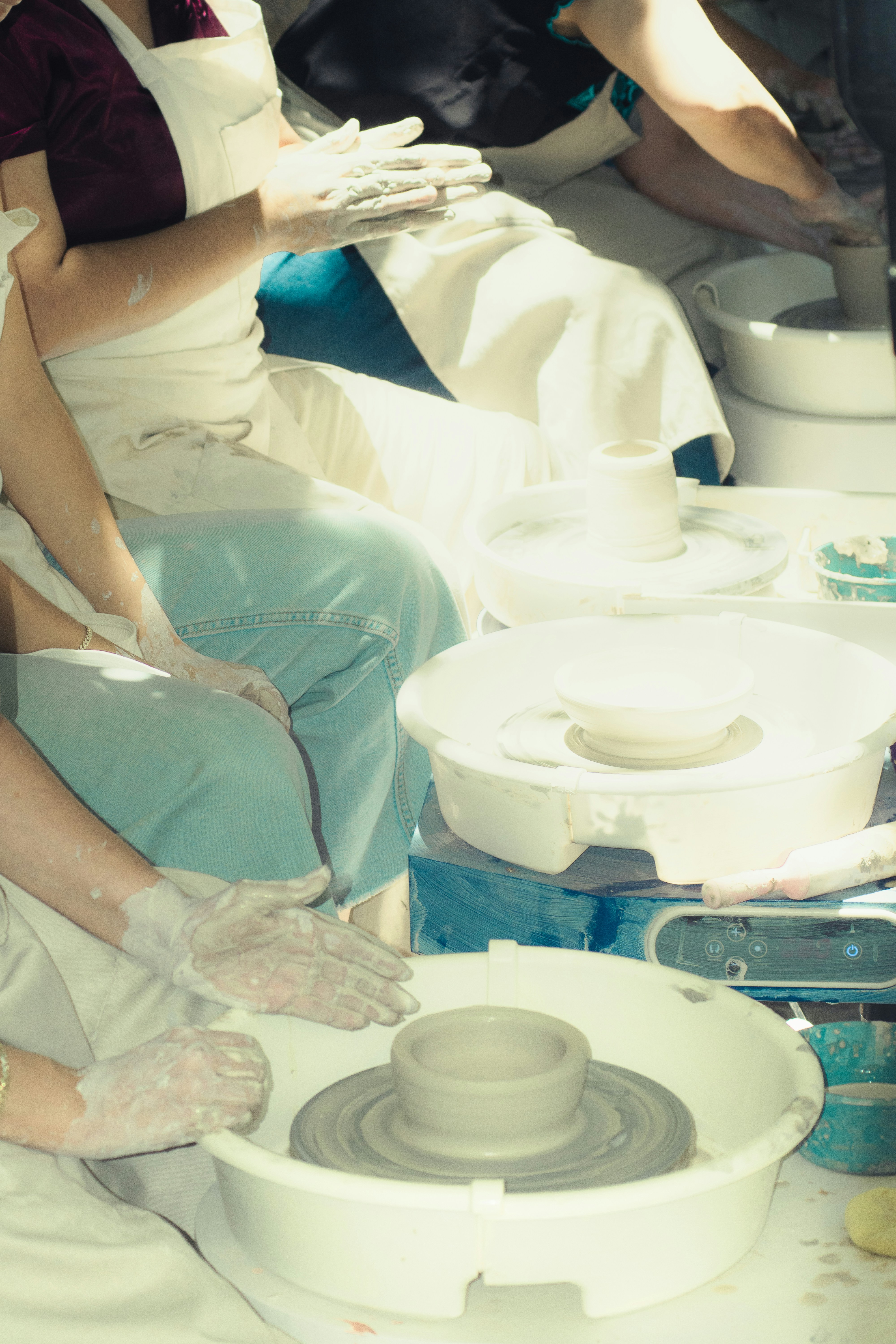 People working on pottery wheels creating ceramics