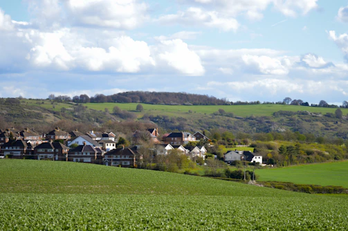 A small village nestled in a green, rolling landscape.