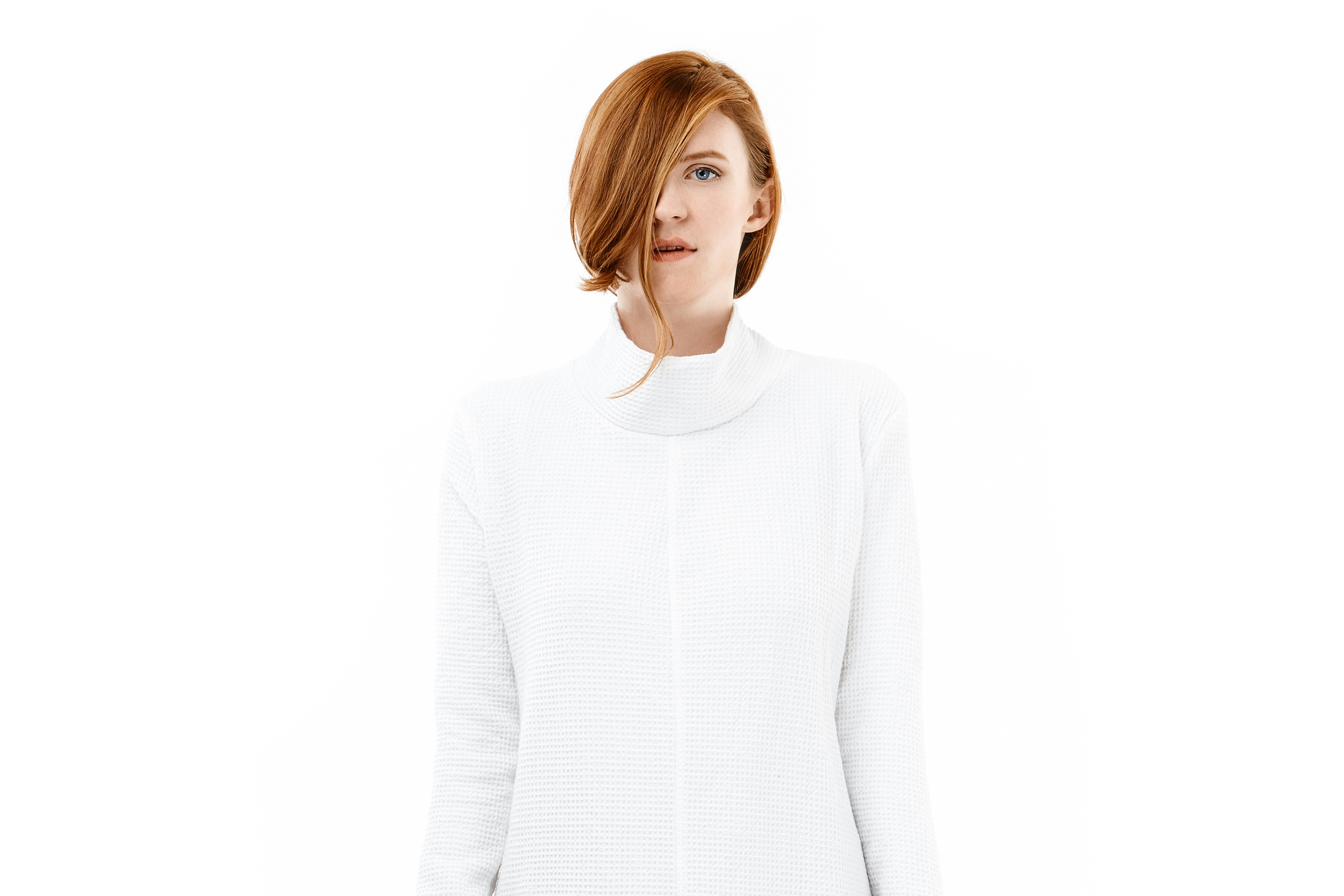 A woman with red hair wearing a white shirt
