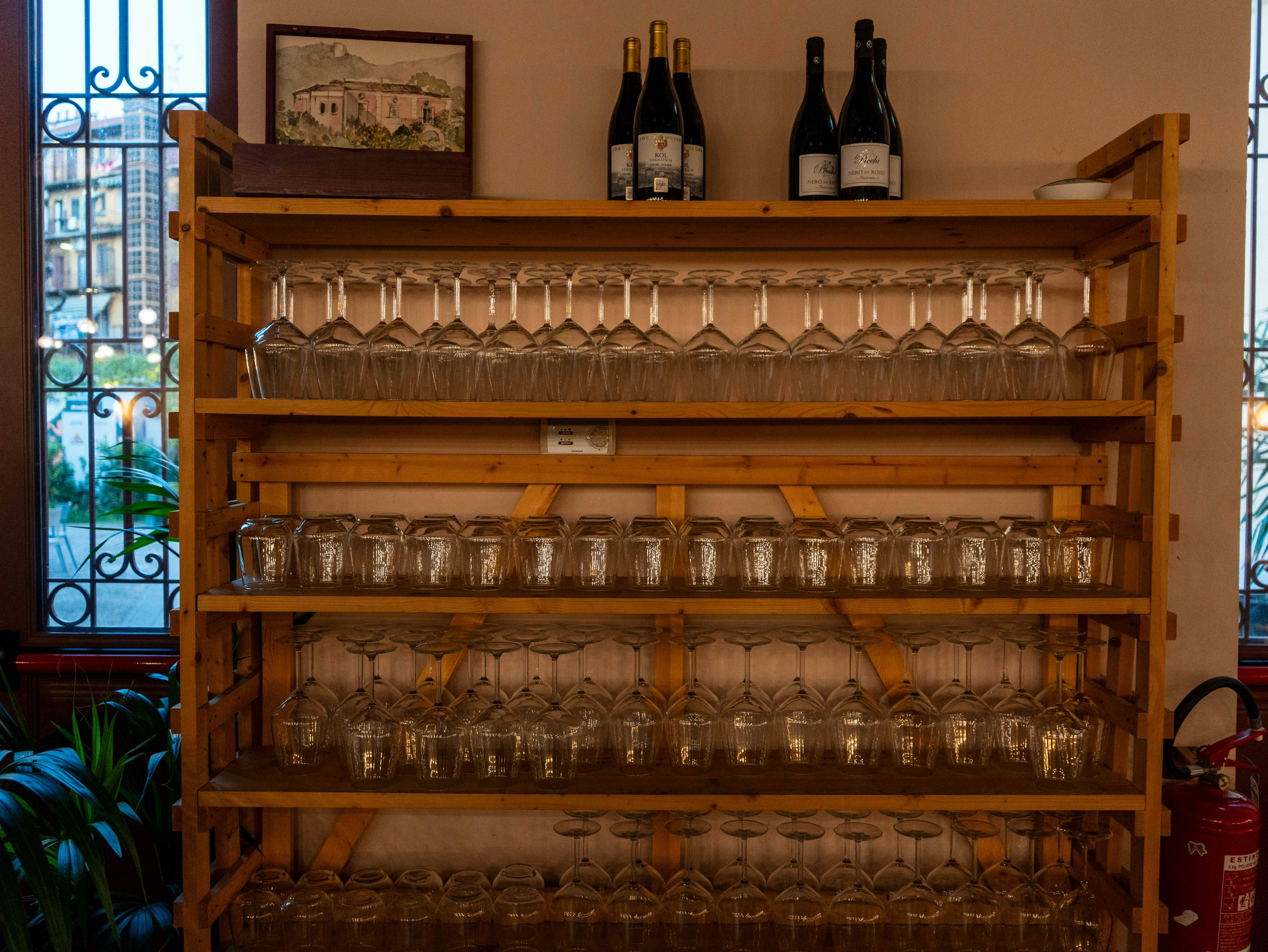 Suporte de madeira com fileiras de taças de vinho limpas