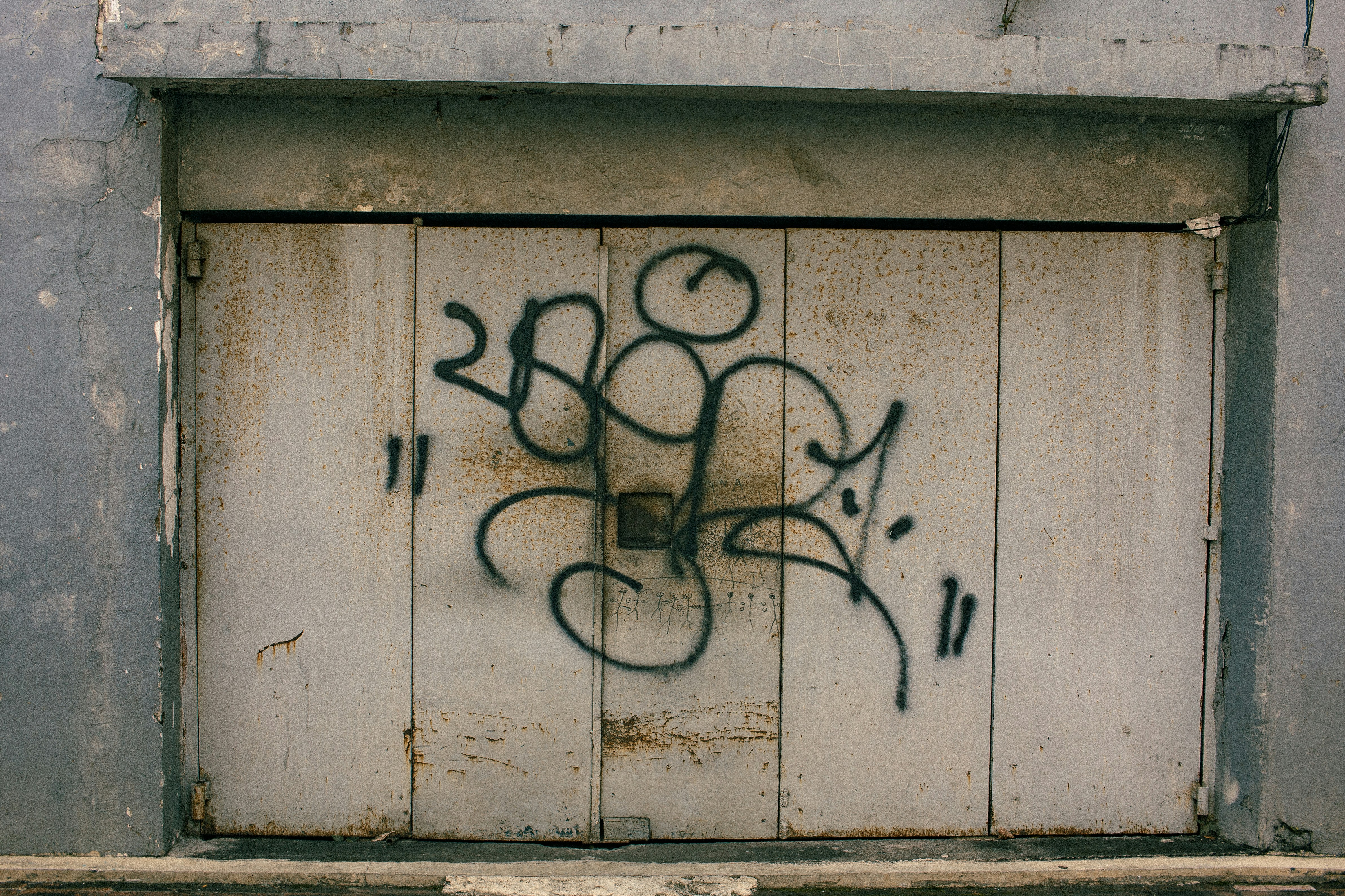 Graffiti on a weathered metal garage door
