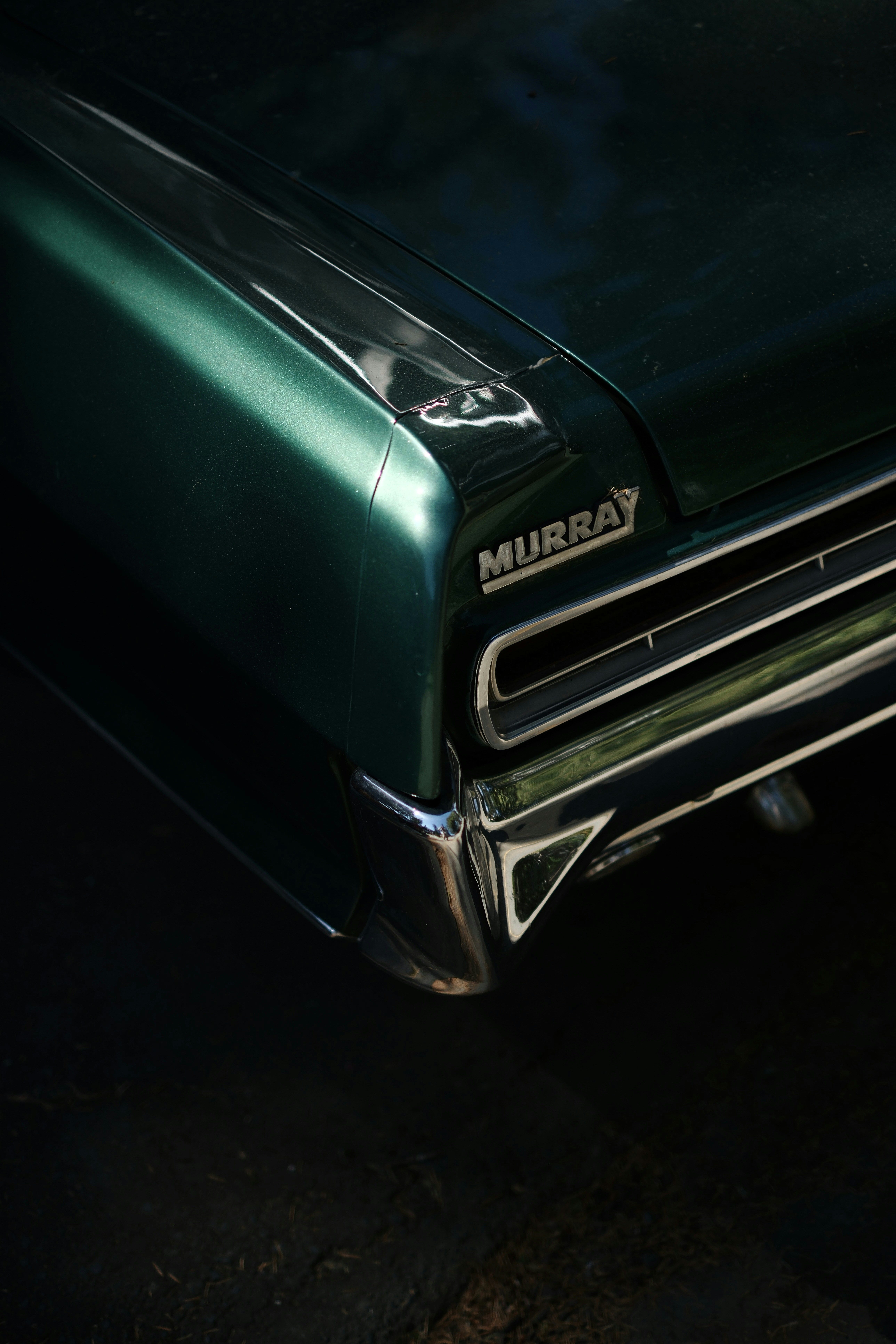 Close-up of a vintage green car's rear detail.
