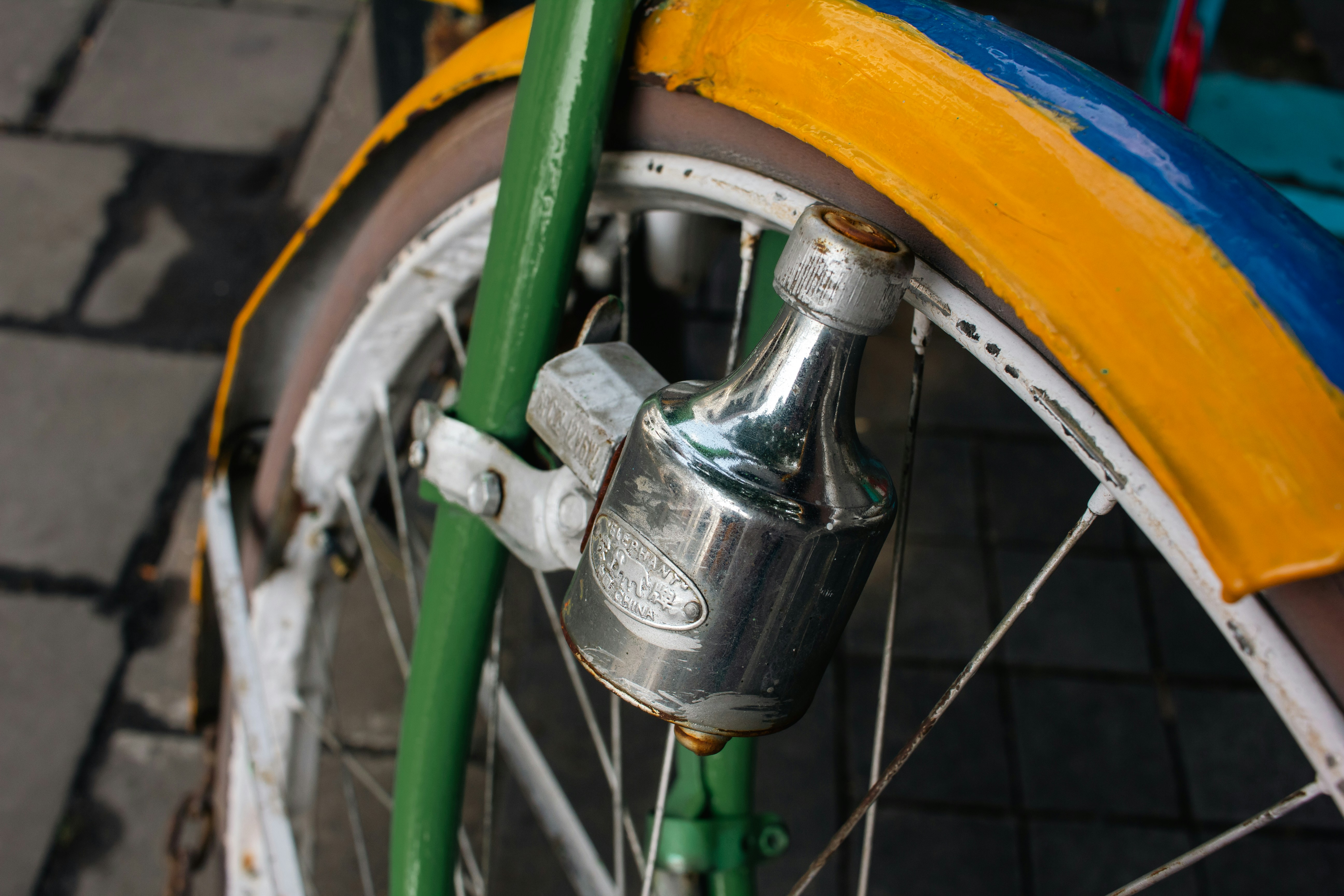 Close-up of a bicycle dynamo attached to the wheel.
