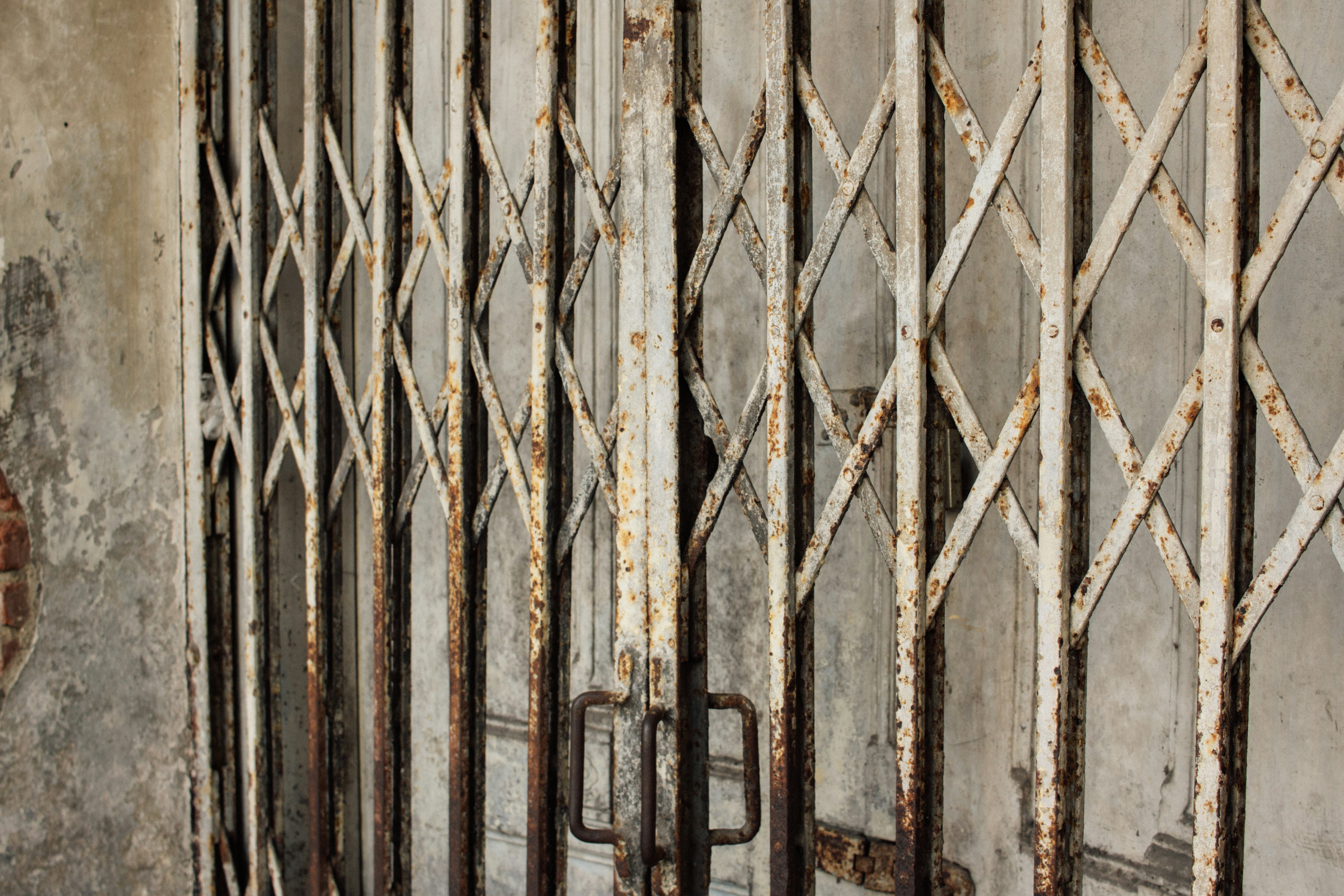 Rusty metal security gate on a weathered wall