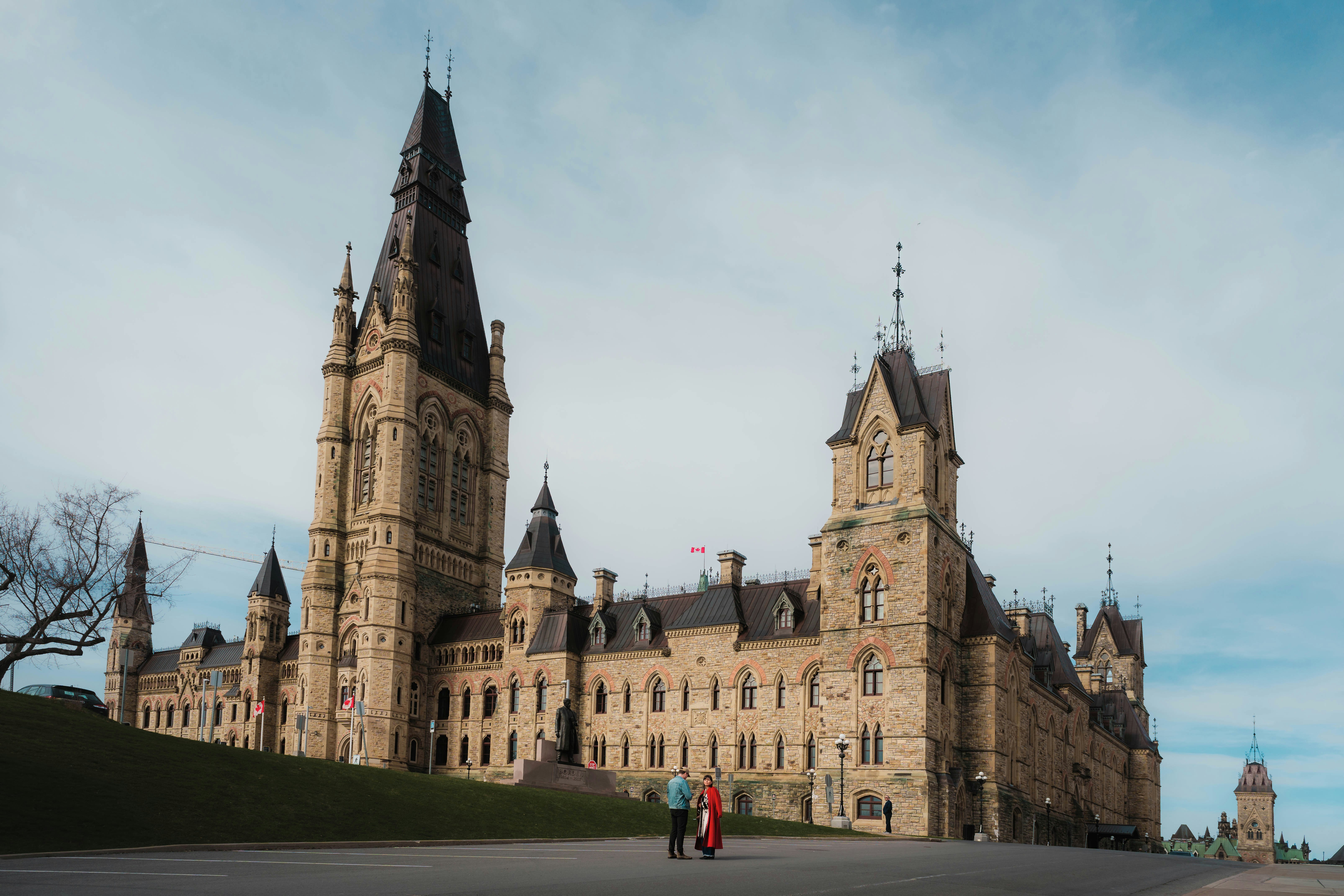 Two people walking in front of the parliament buildings