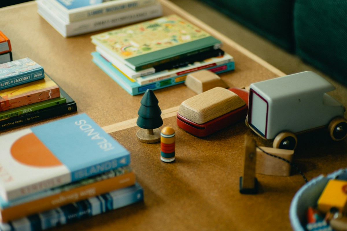 Stack of books and toys on a wooden table, ideal for small group volunteer projects in community service settings