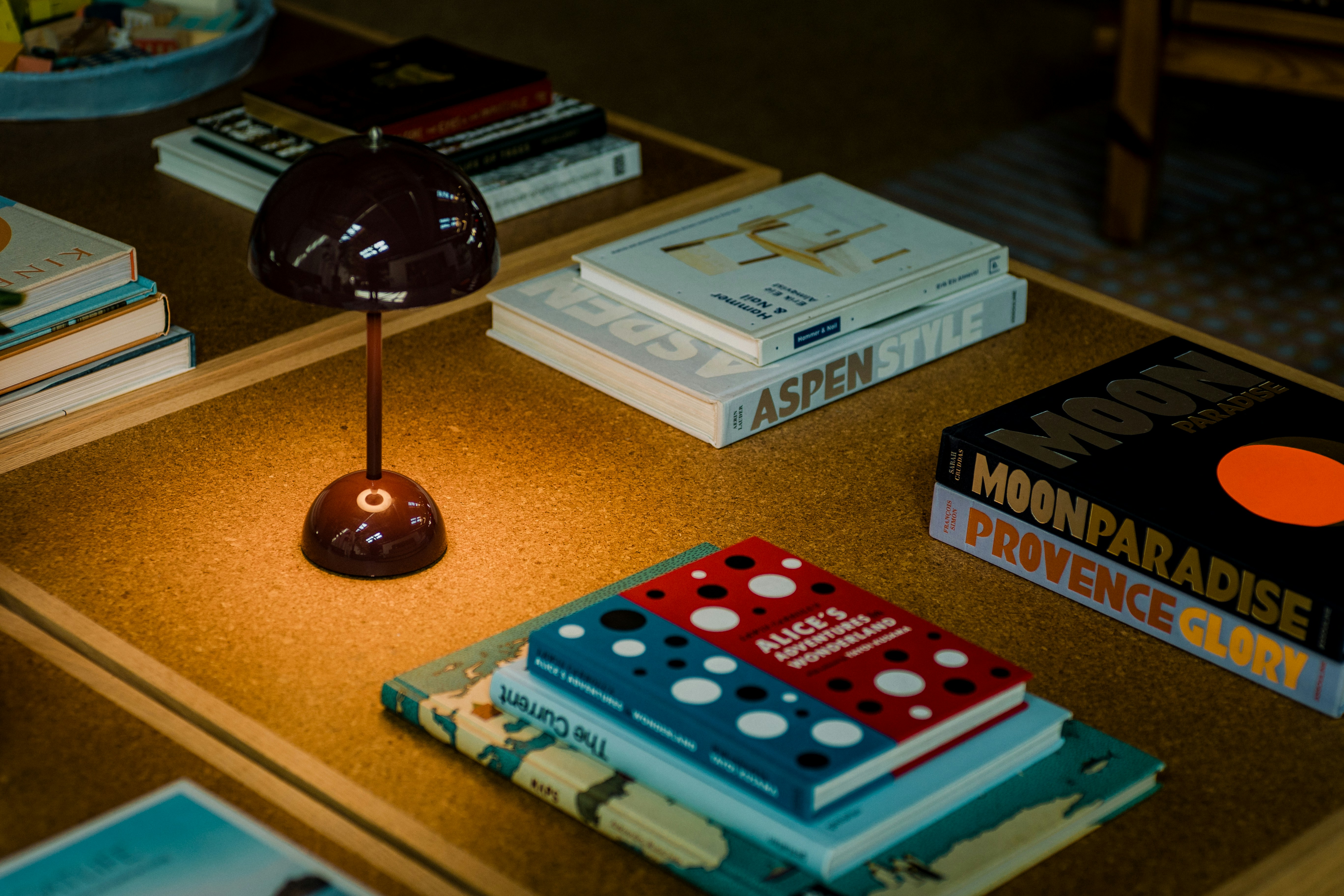 A small lamp illuminates books on a table.