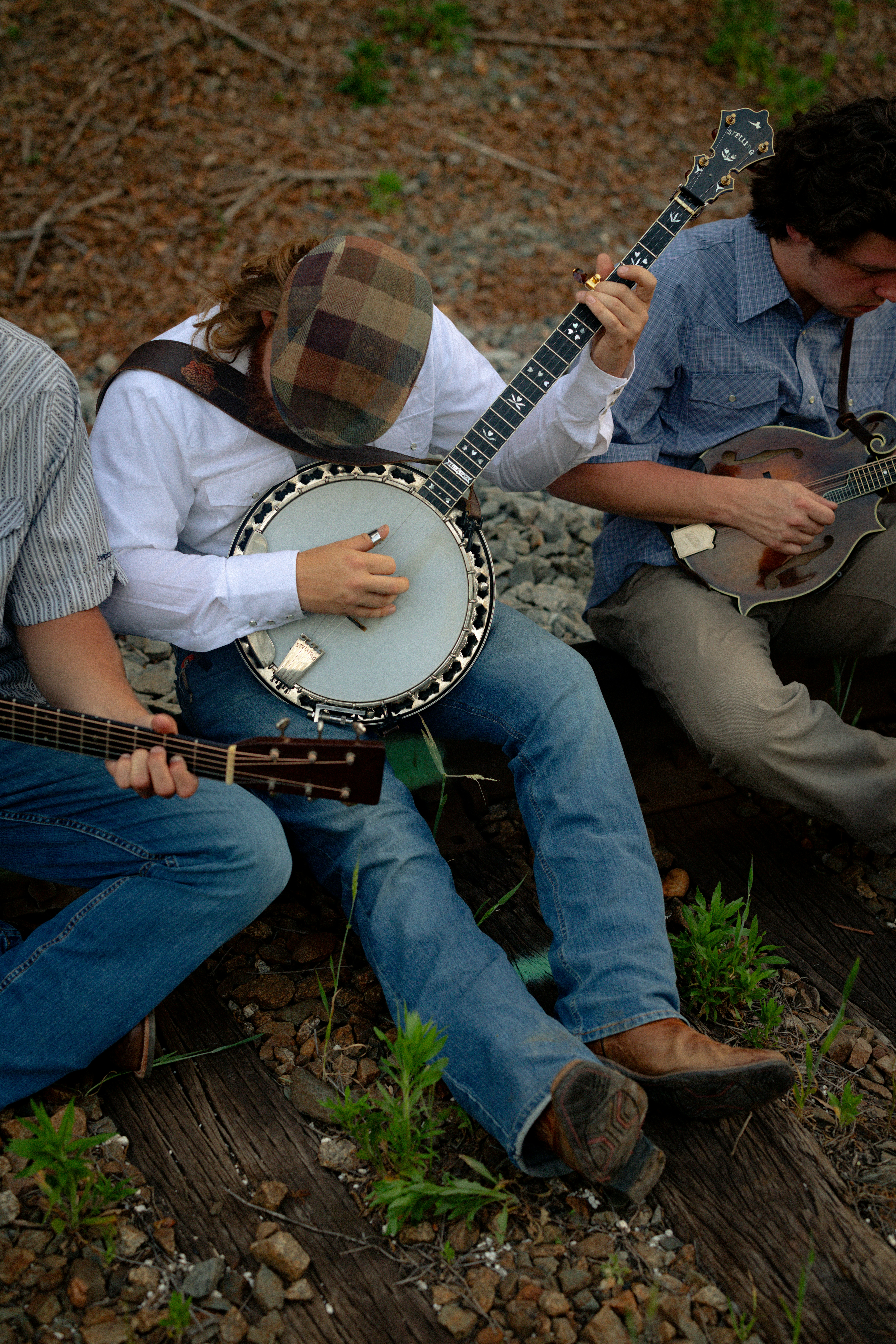 Musicians playing banjo, guitar, and mandolin outdoors