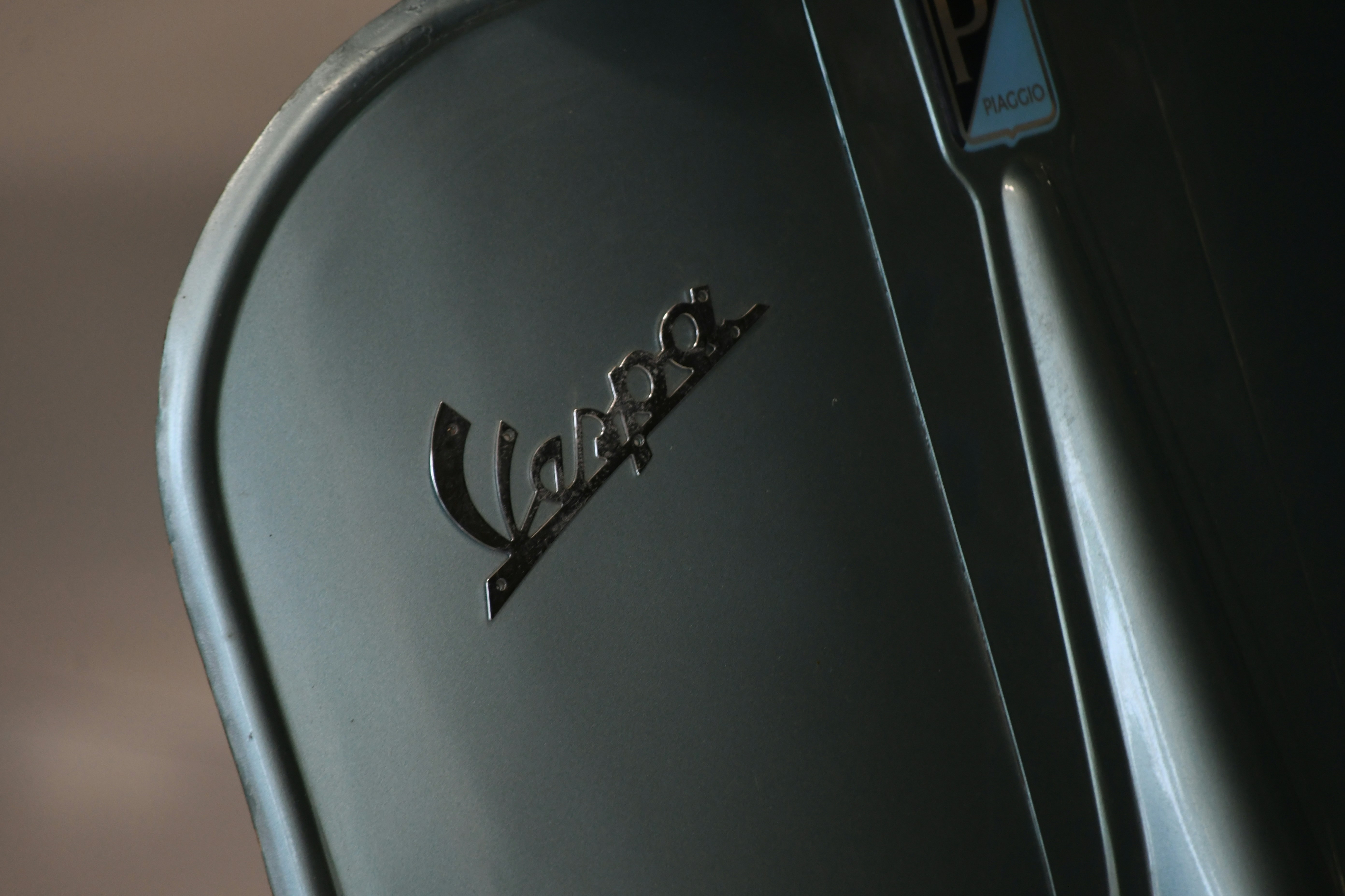 Close-up of a vintage vespa scooter emblem.