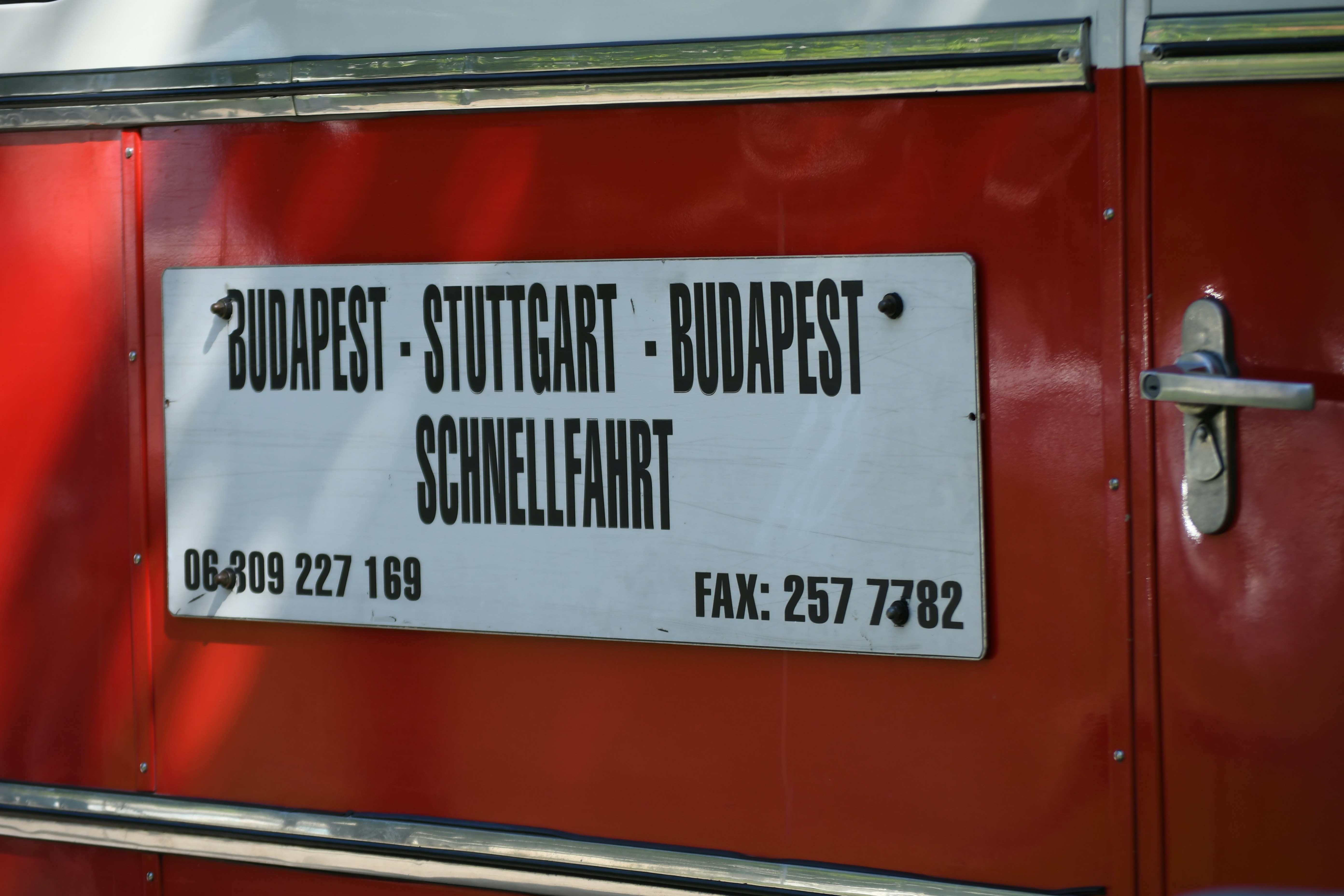 Sign on red bus lists destinations and phone numbers