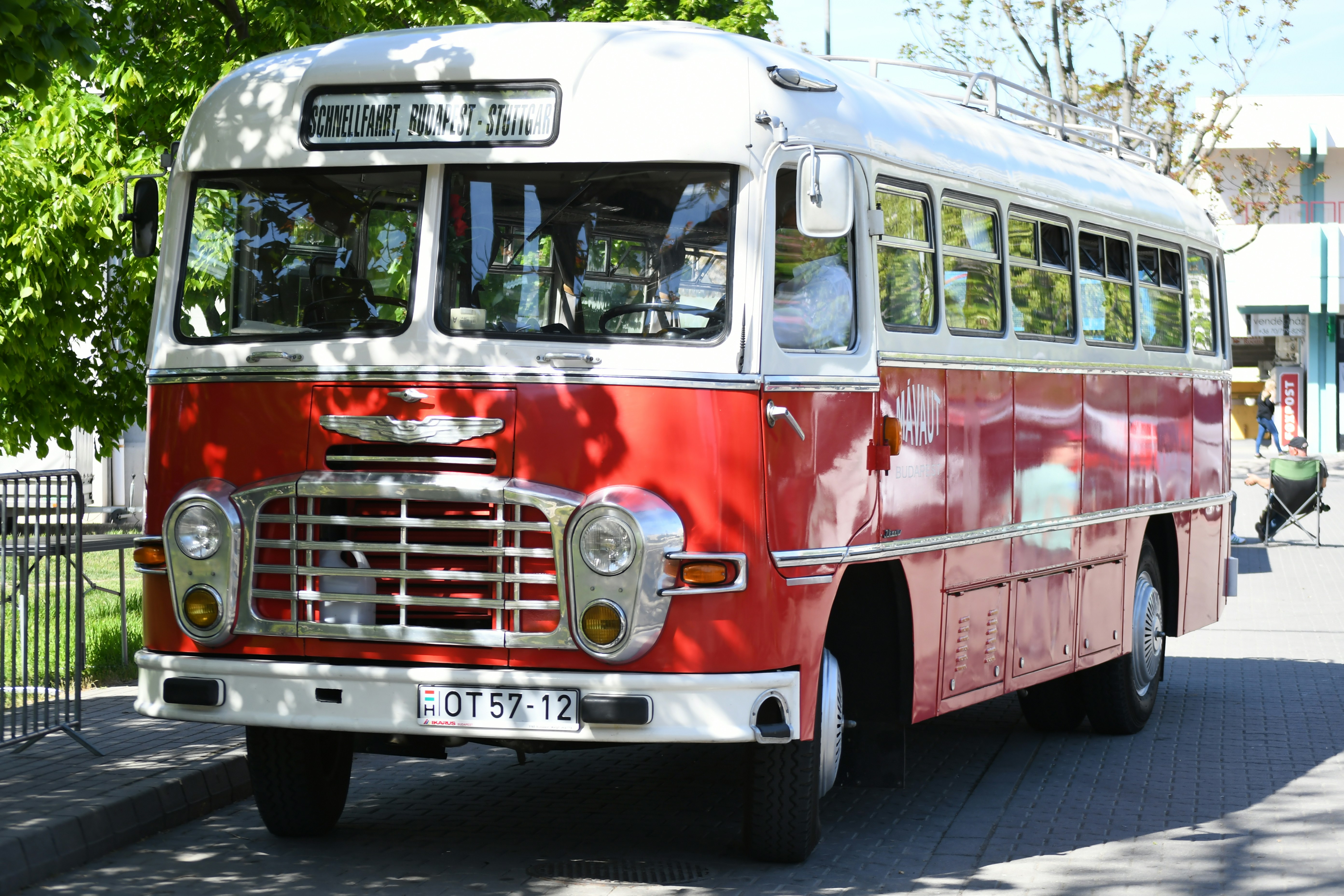 A vintage red and white bus parked outdoors.
