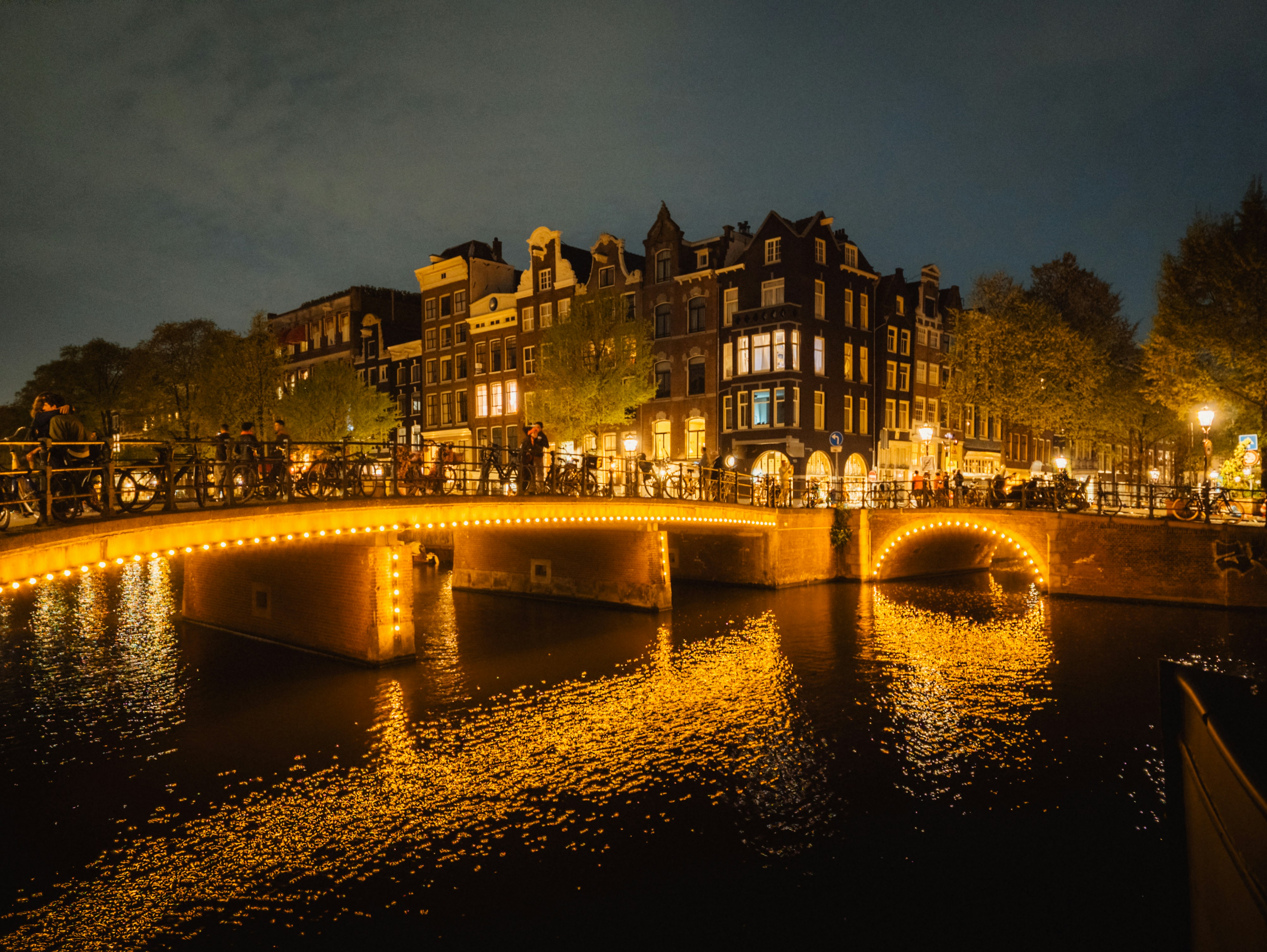 Illuminated bridge over a canal at night
