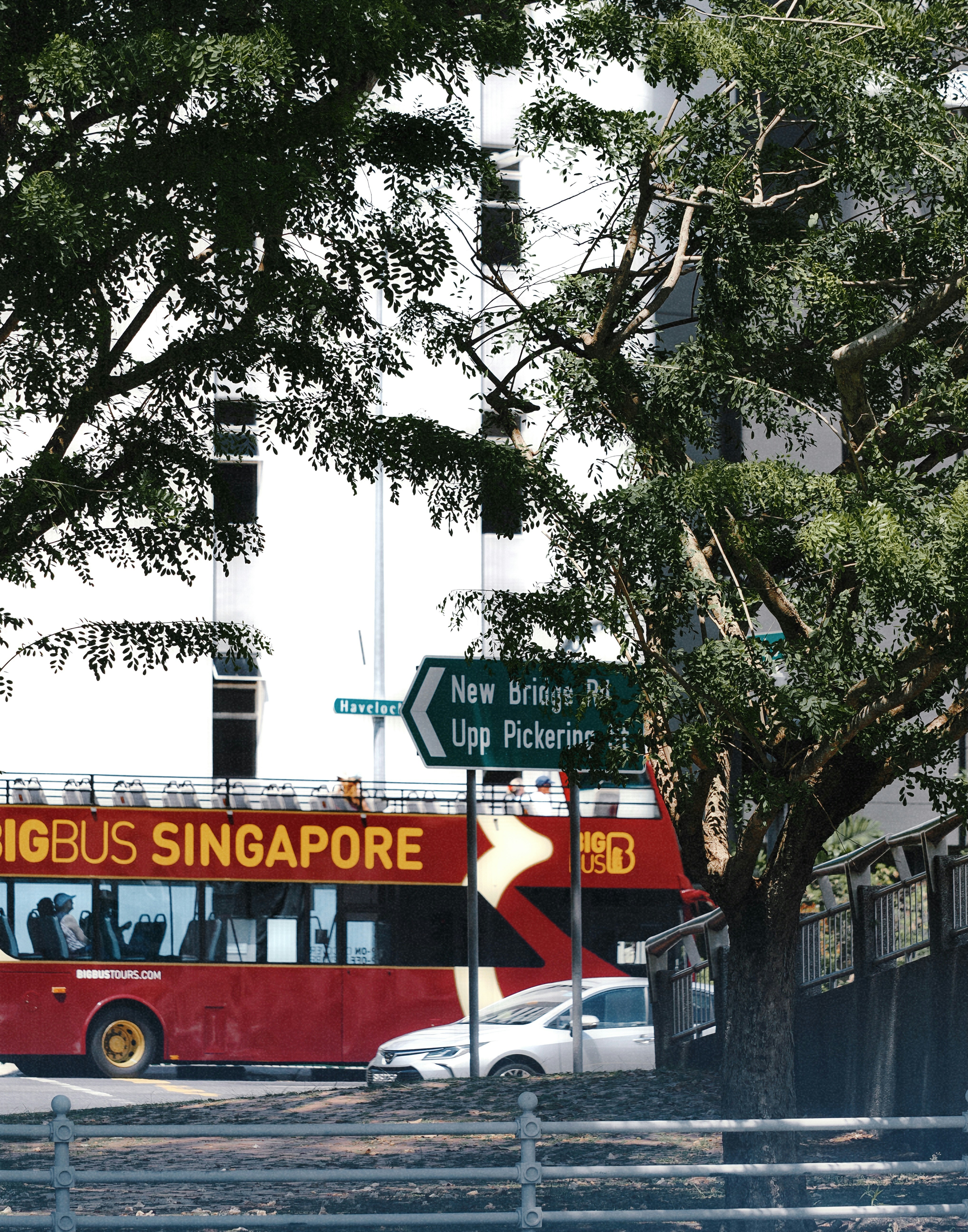 Red double-decker bus in singapore with street signs