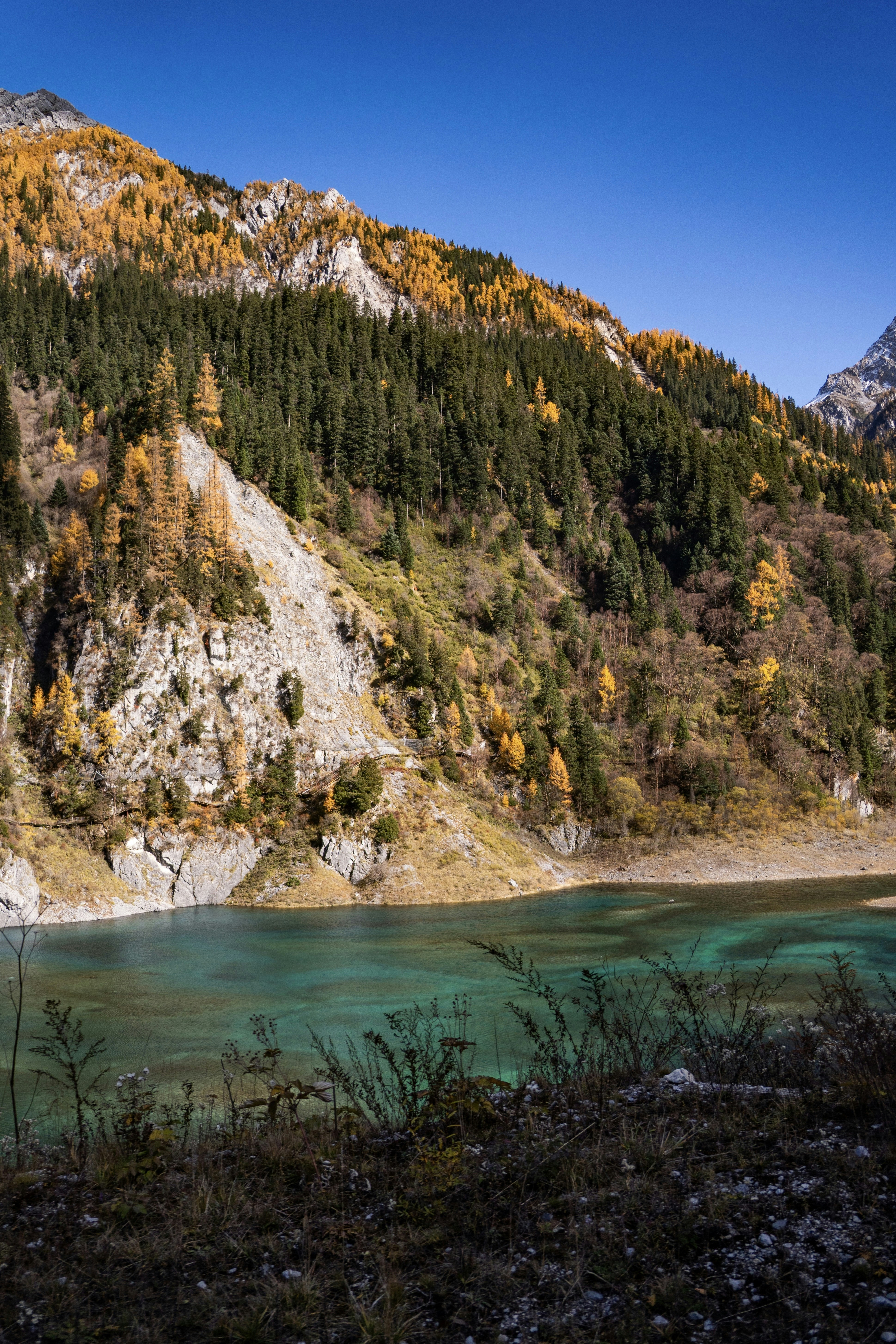 Turquoise lake nestled at the base of a mountain.