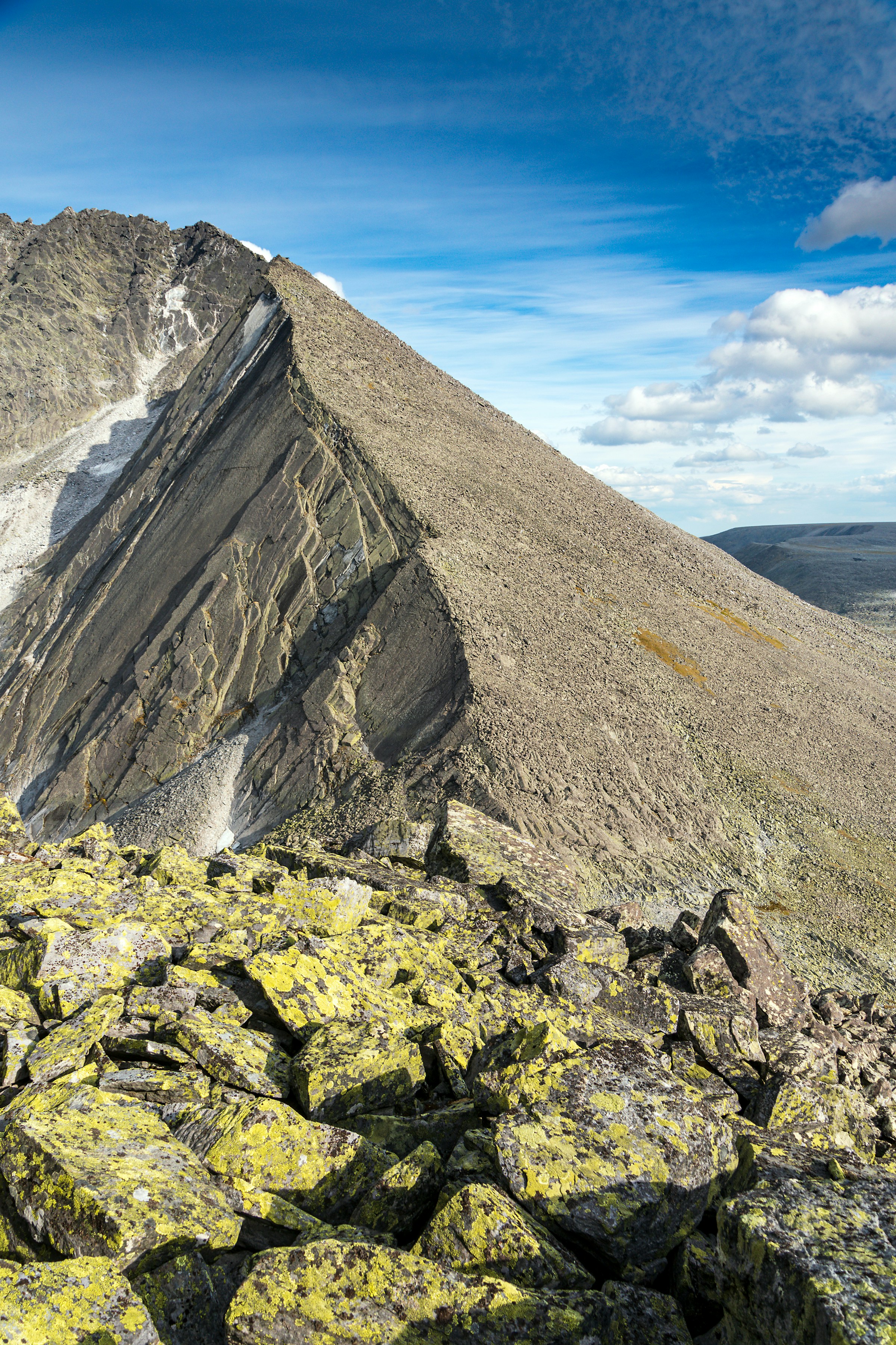 Lereng gunung berbatu di bawah langit biru