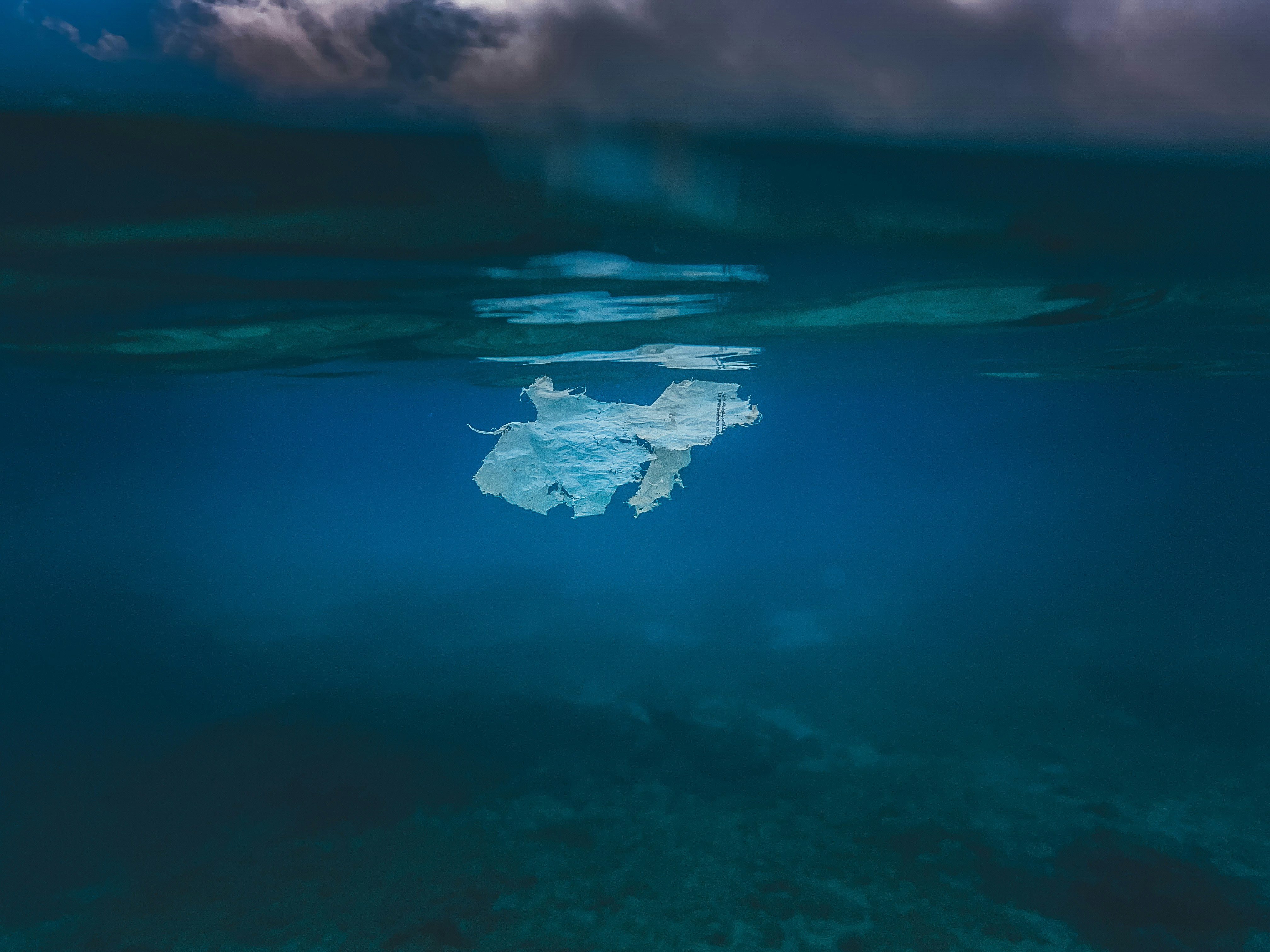 Sac plastique flottant dans une eau bleue profonde de l’océan