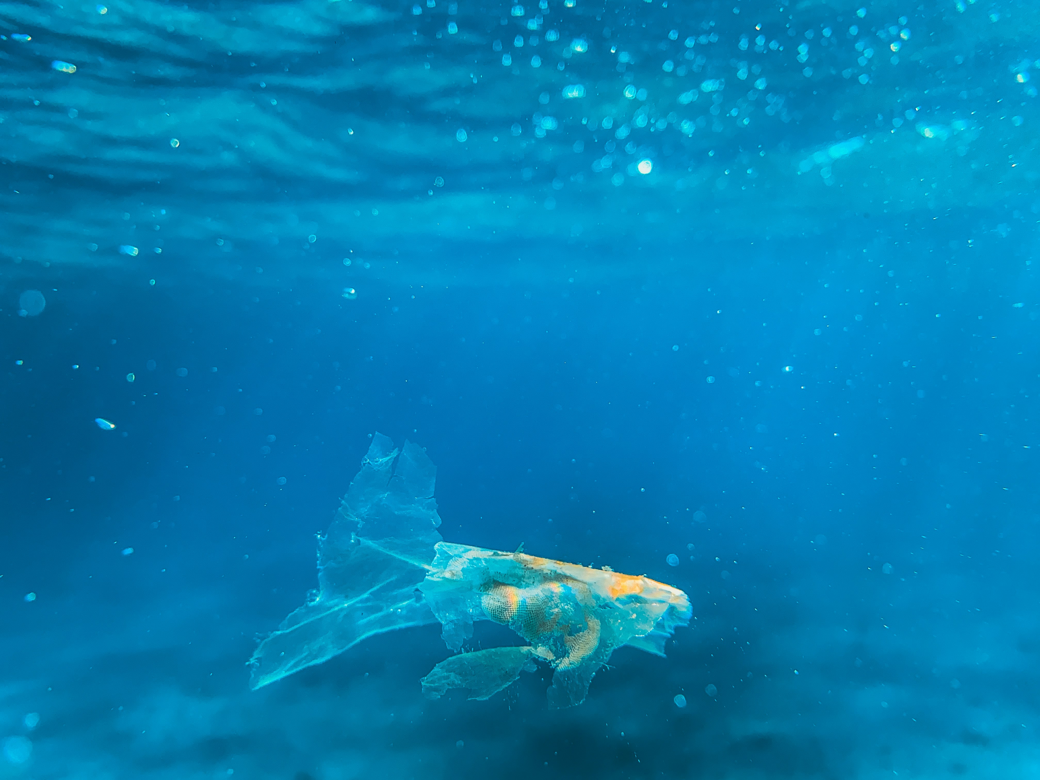Un sac plastique flottant sous l’eau dans l’océan.