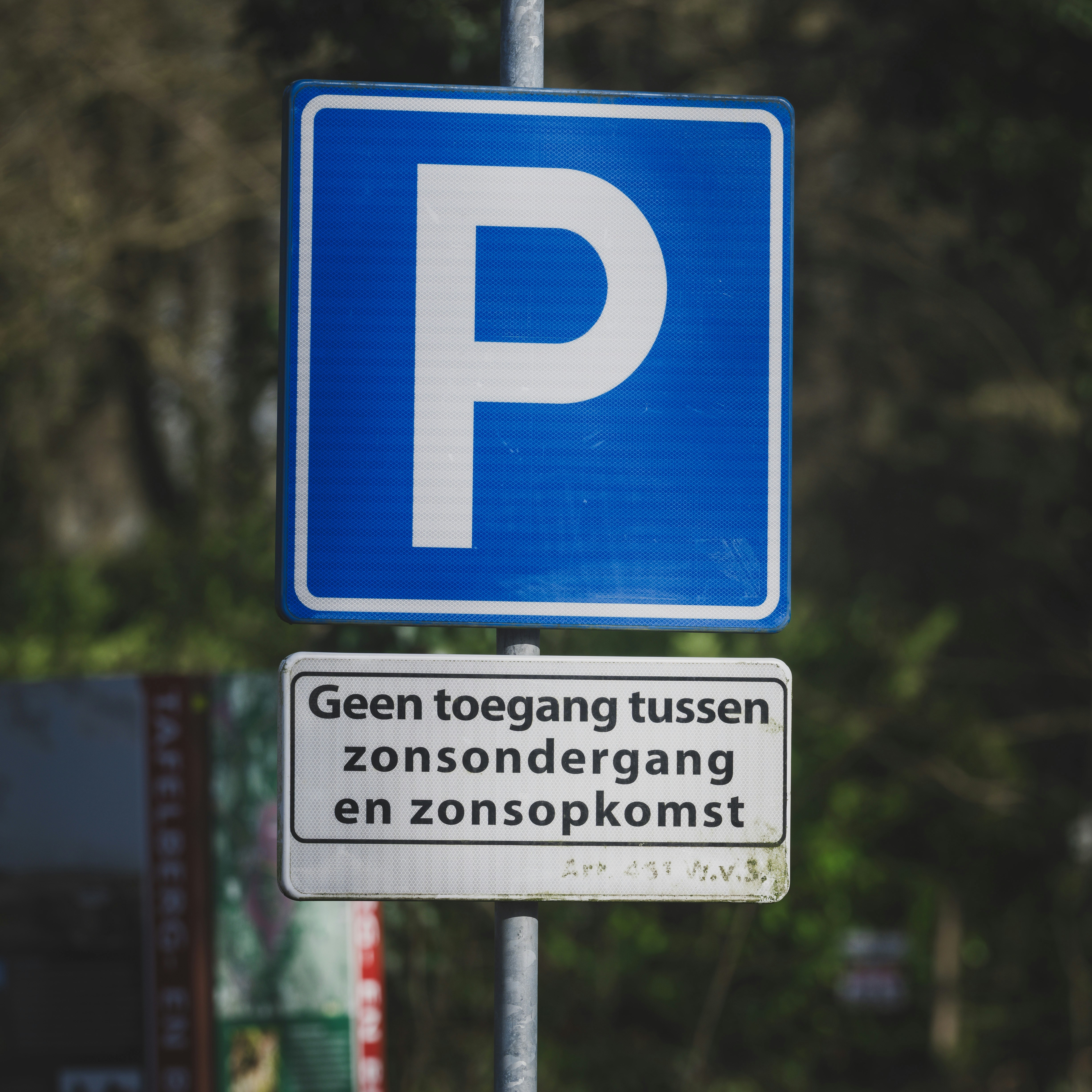Blue parking sign with dutch text below