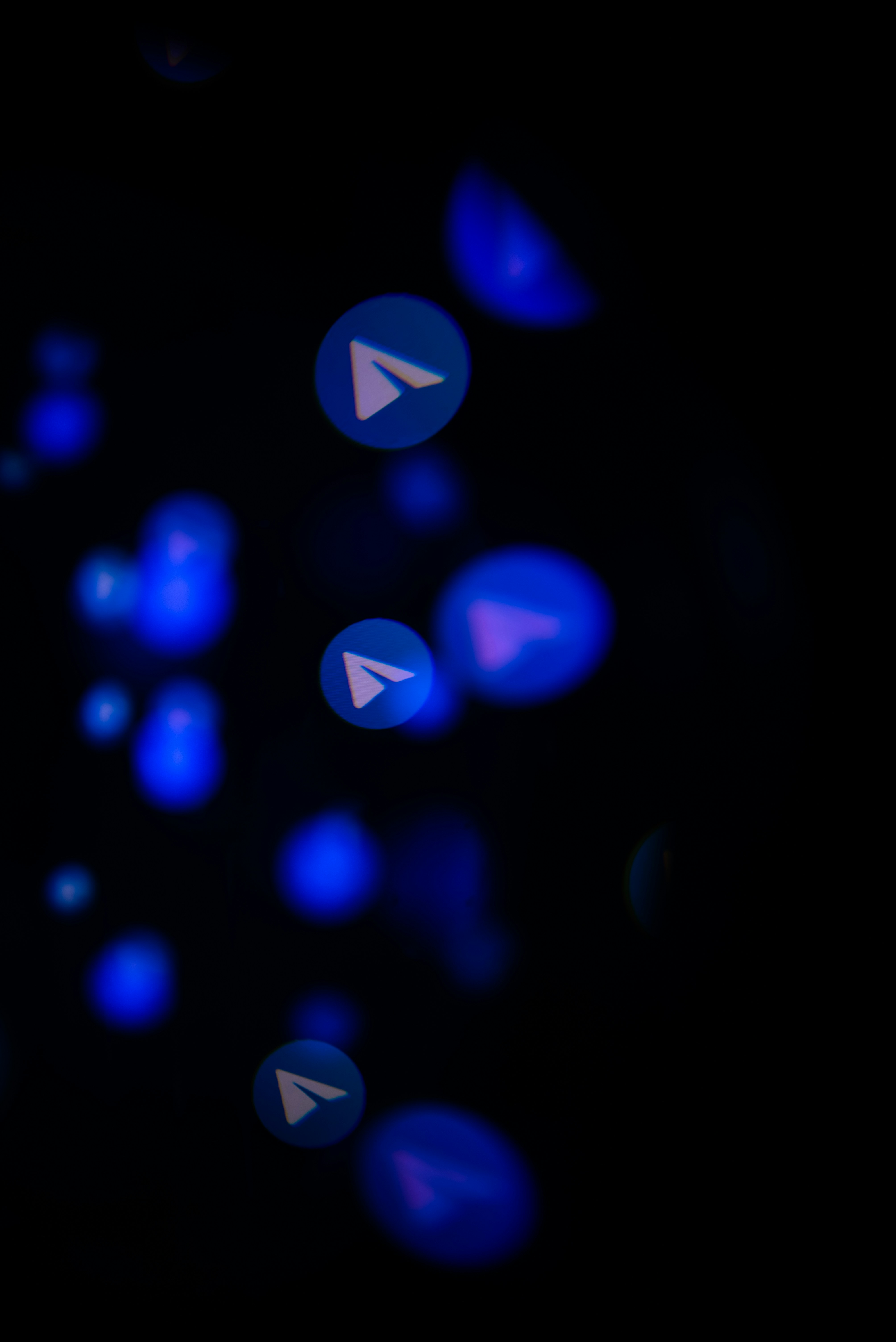 Ícones do logo do Telegram em luzes bokeh azuis