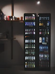 Two illuminated vending machines filled with beverages.