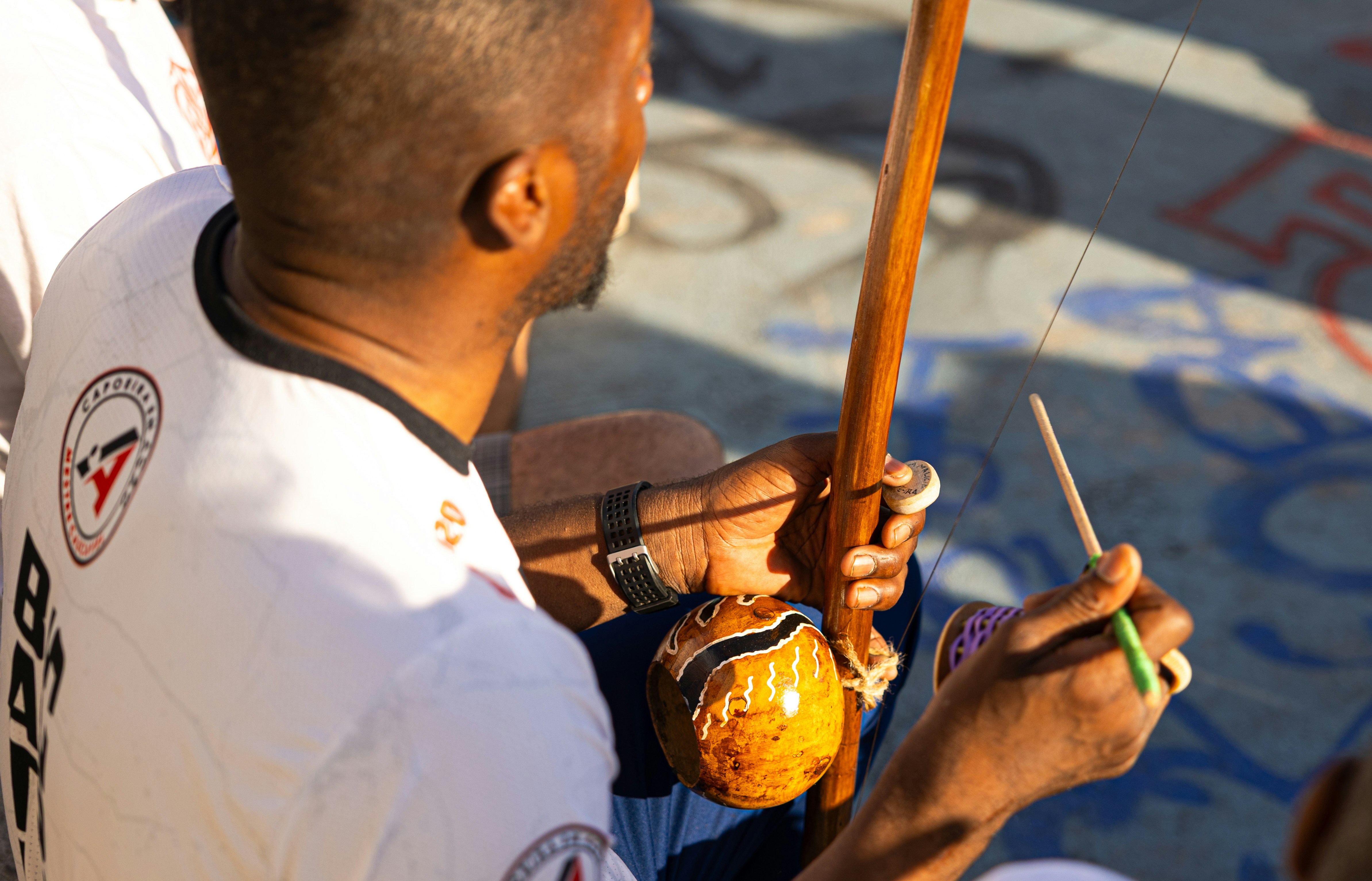 Man playing a berimbau during a capoeira performance.