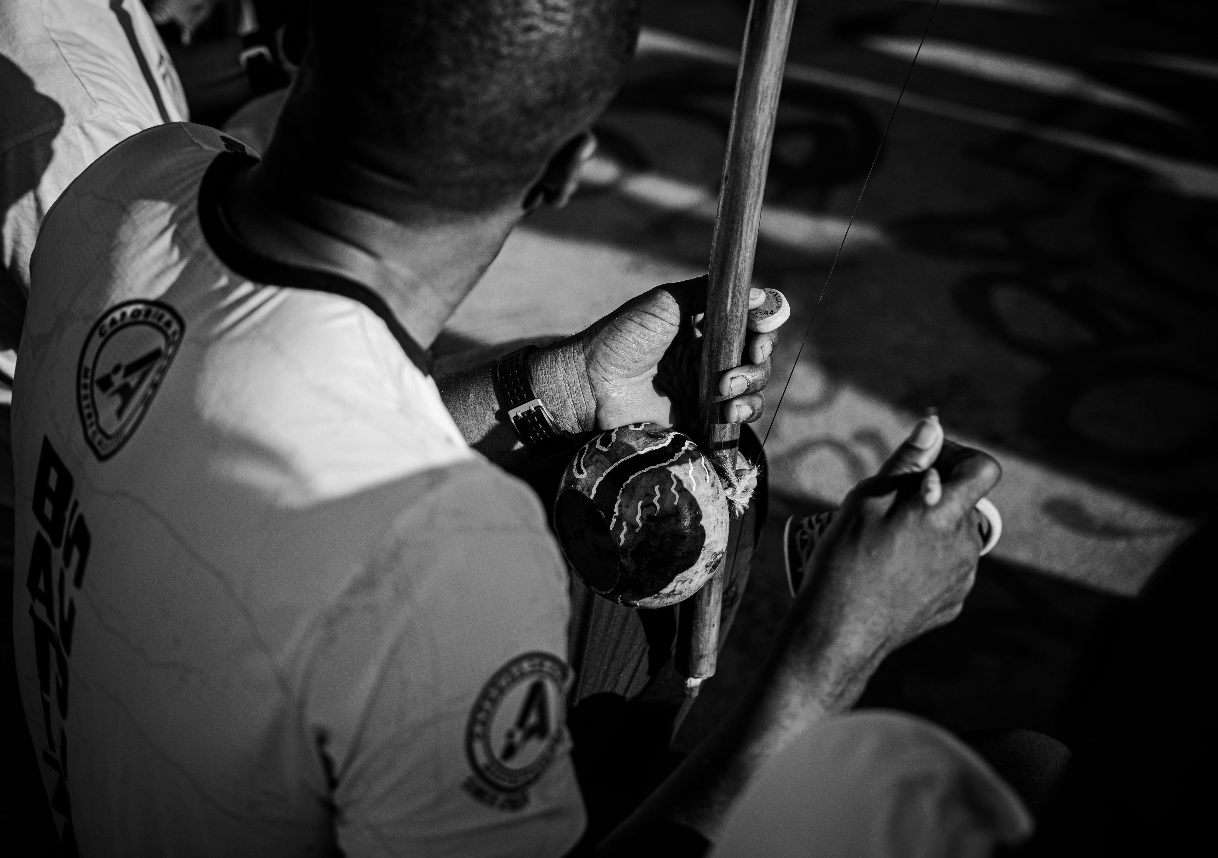 Man playing a berimbau during a capoeira performance.