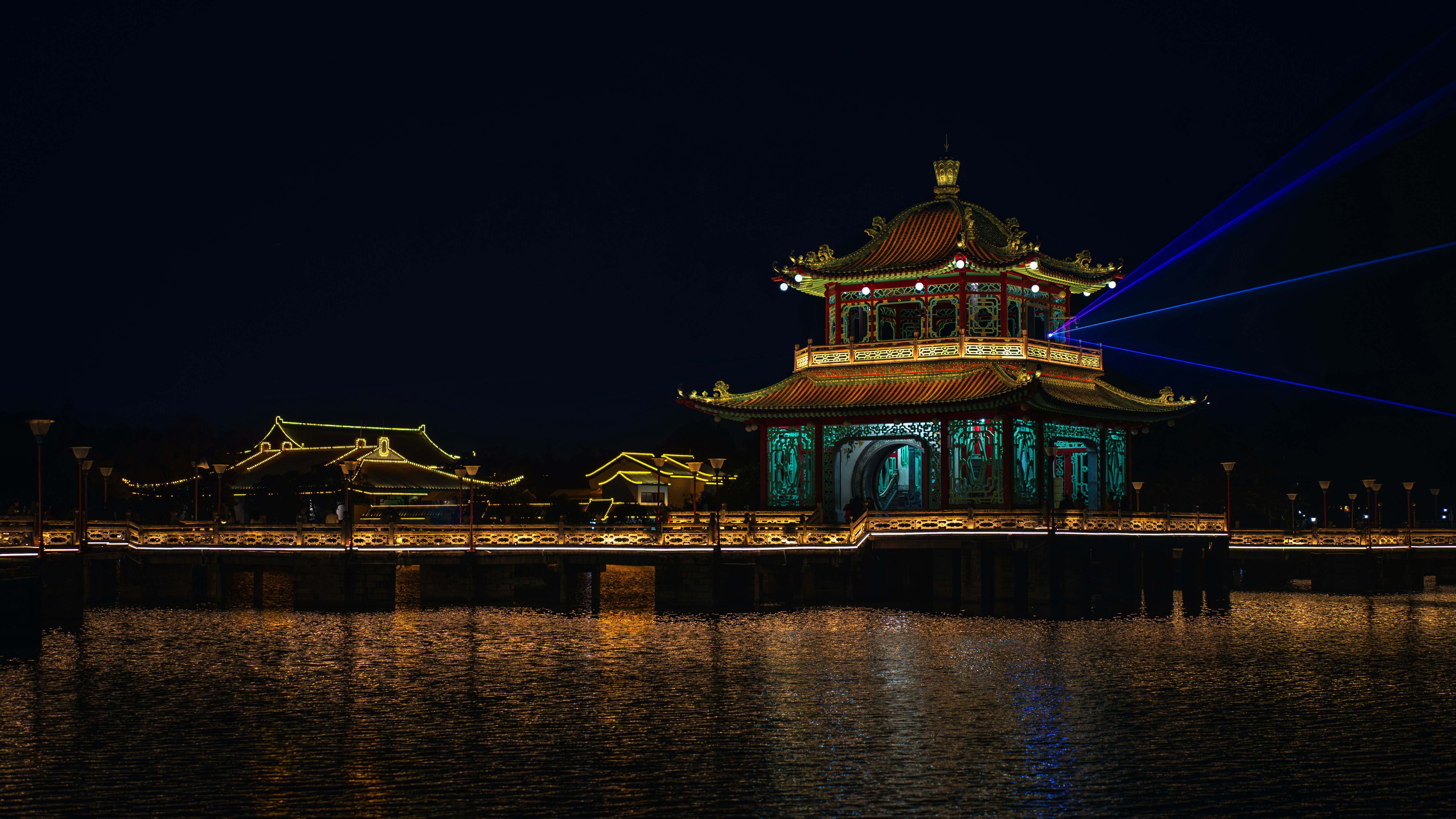 Traditional chinese buildings illuminated at night by the water