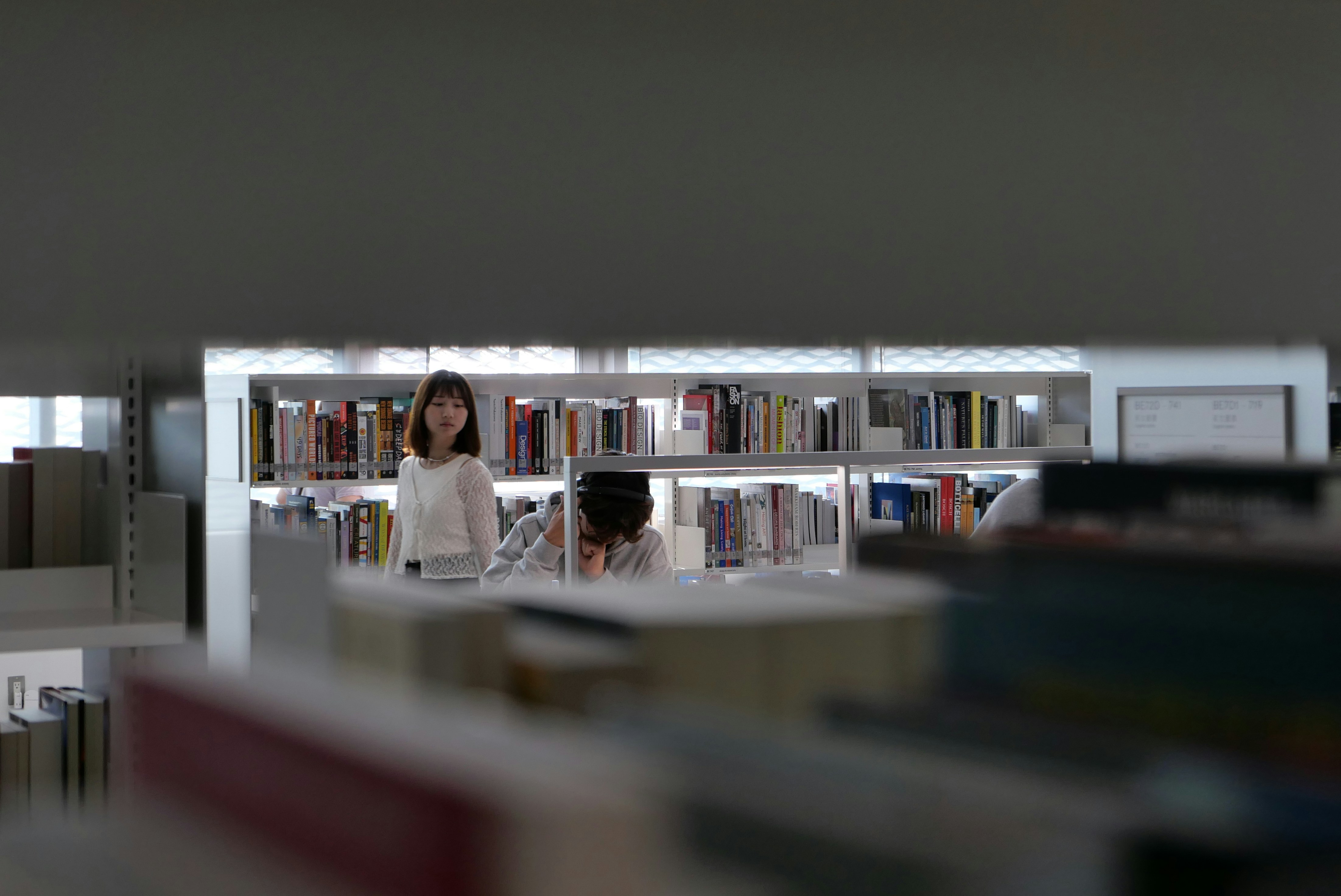 Woman standing in a library with bookshelves