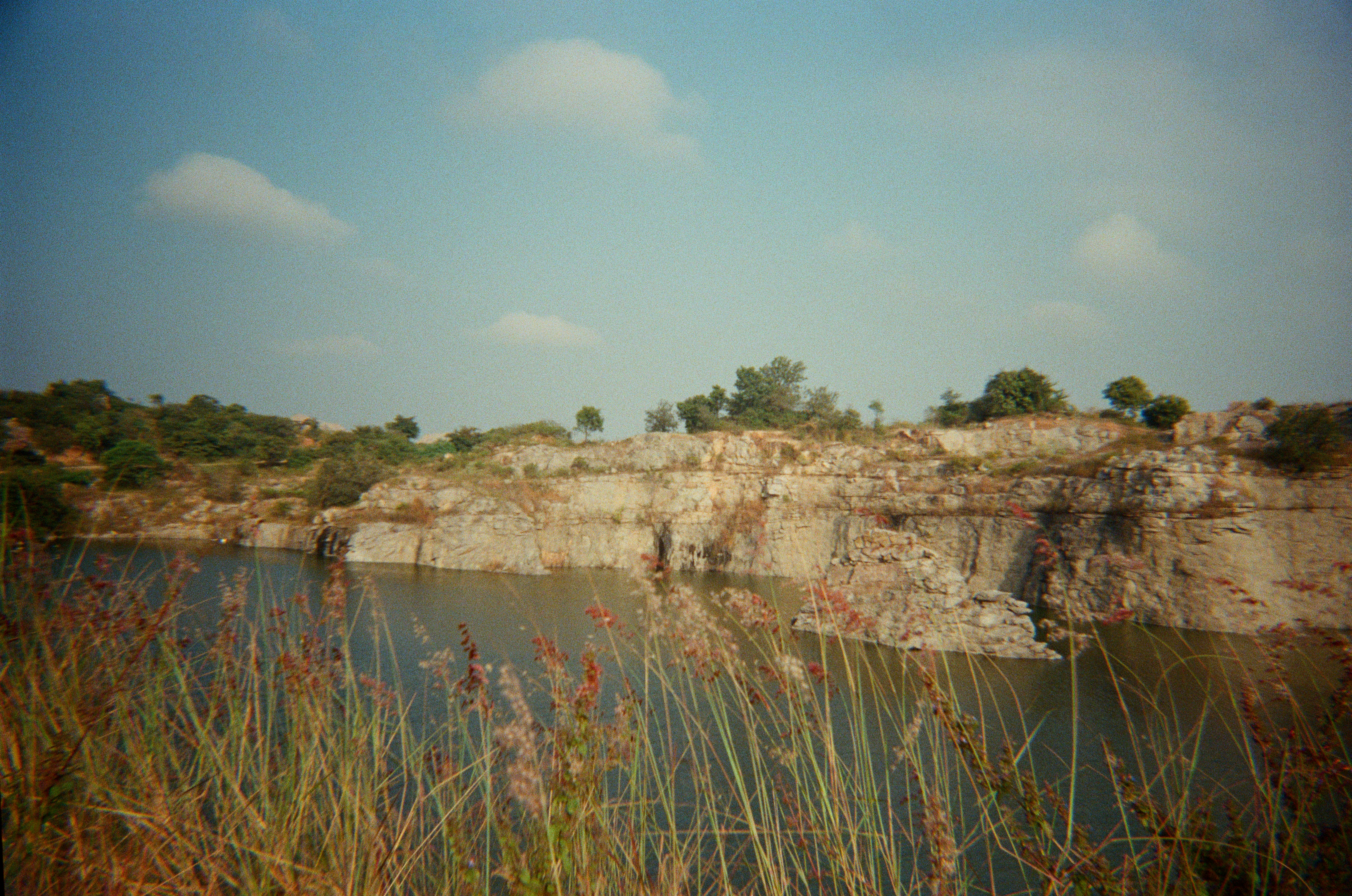 Rocky cliff face overlooking a calm body of water.