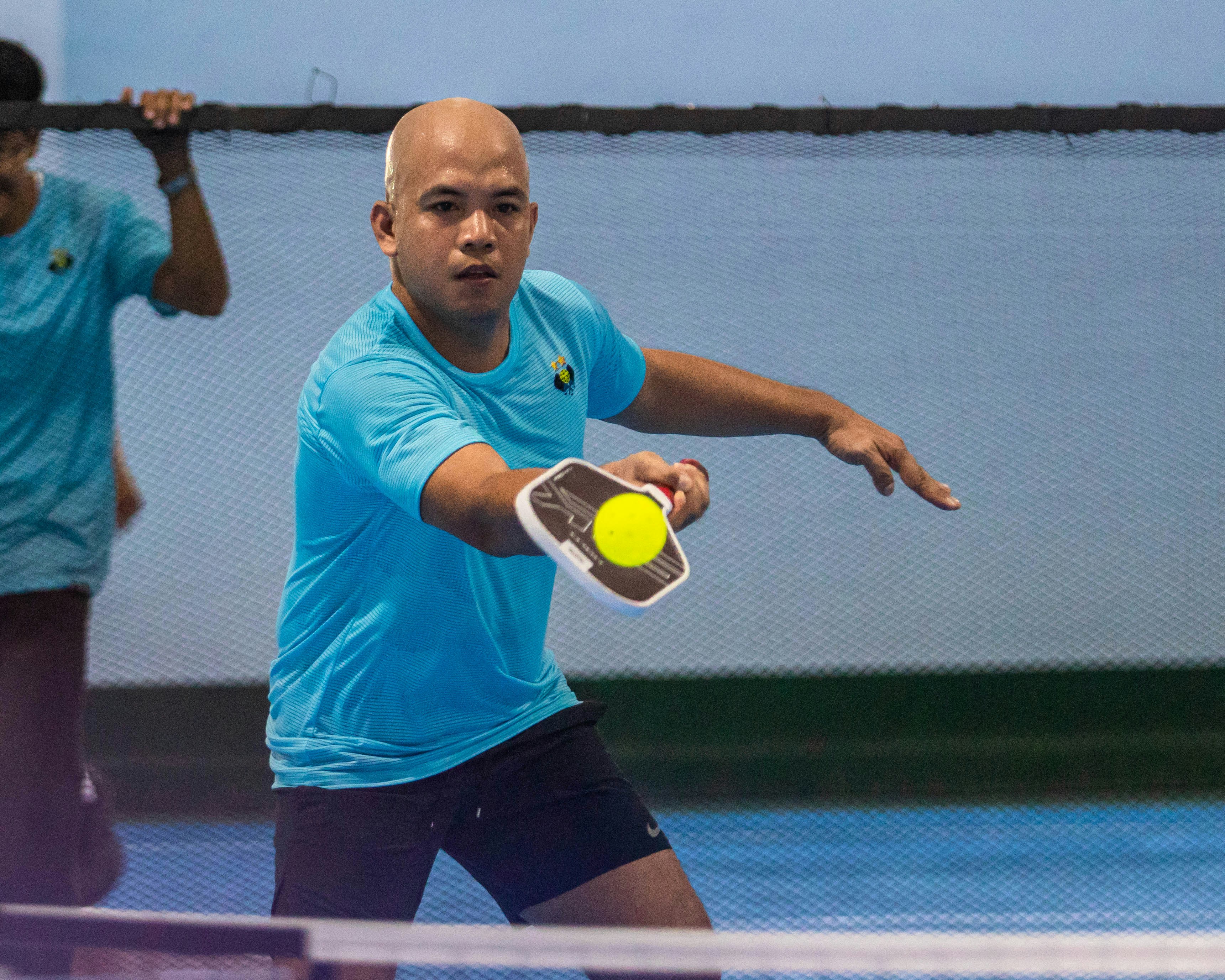 Mann spielt Pickleball und schlägt den Ball