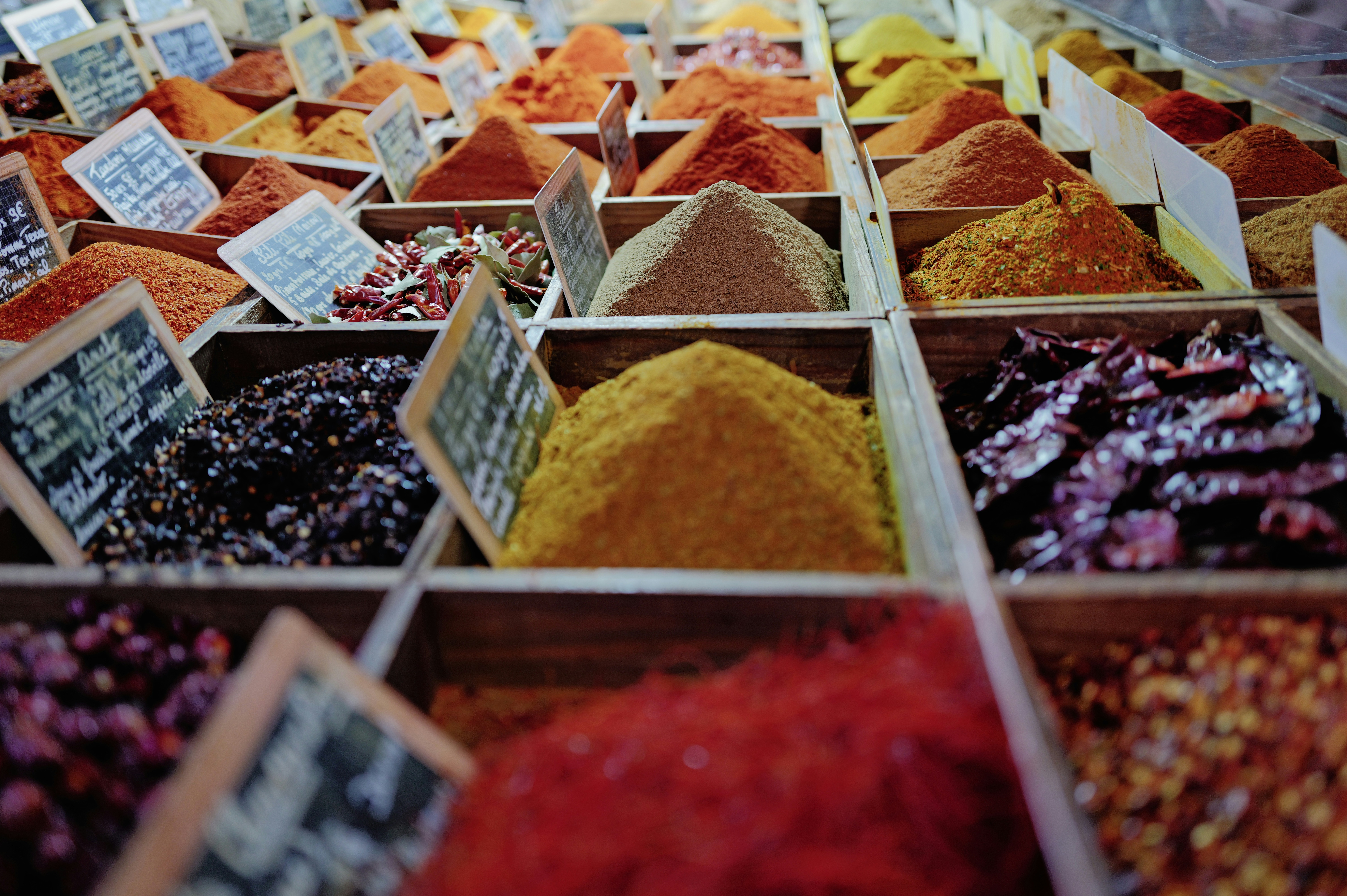 Colorful assortment of spices in wooden crates at market