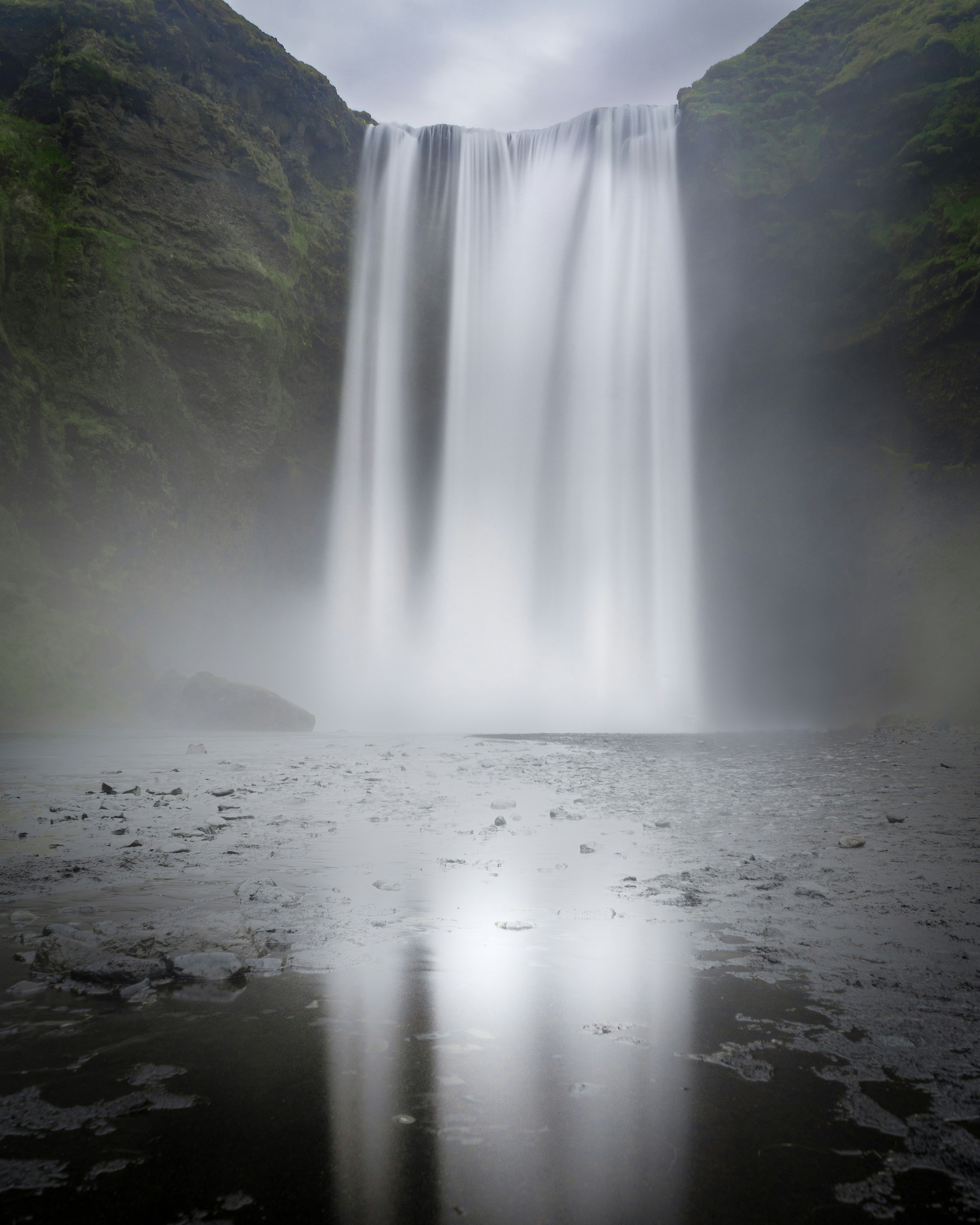 A majestic waterfall cascades down a rocky cliff face
