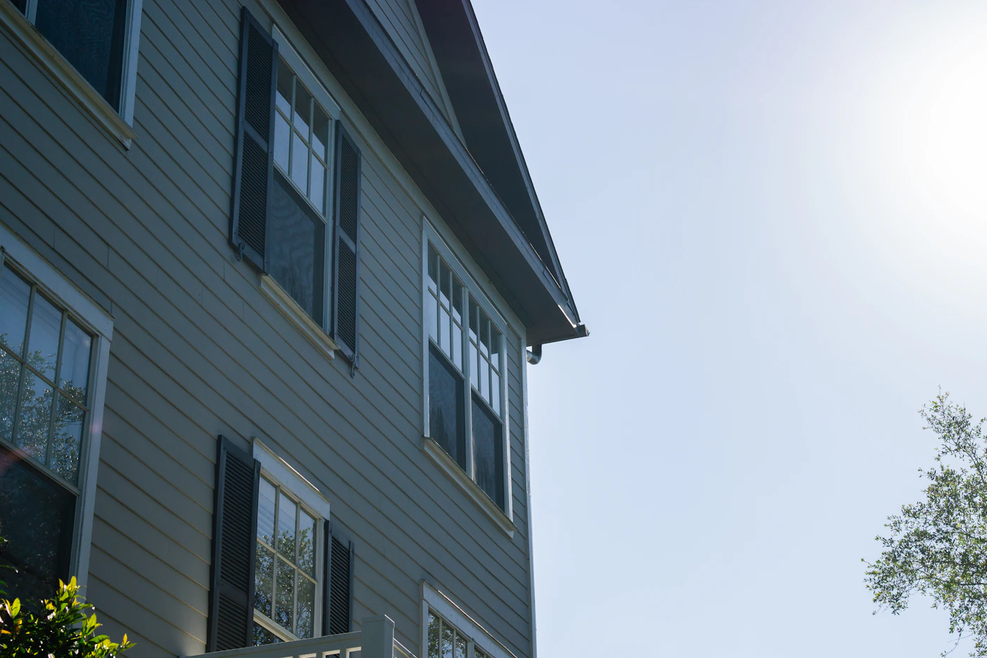 Close view of gray residential siding, shutters and windows