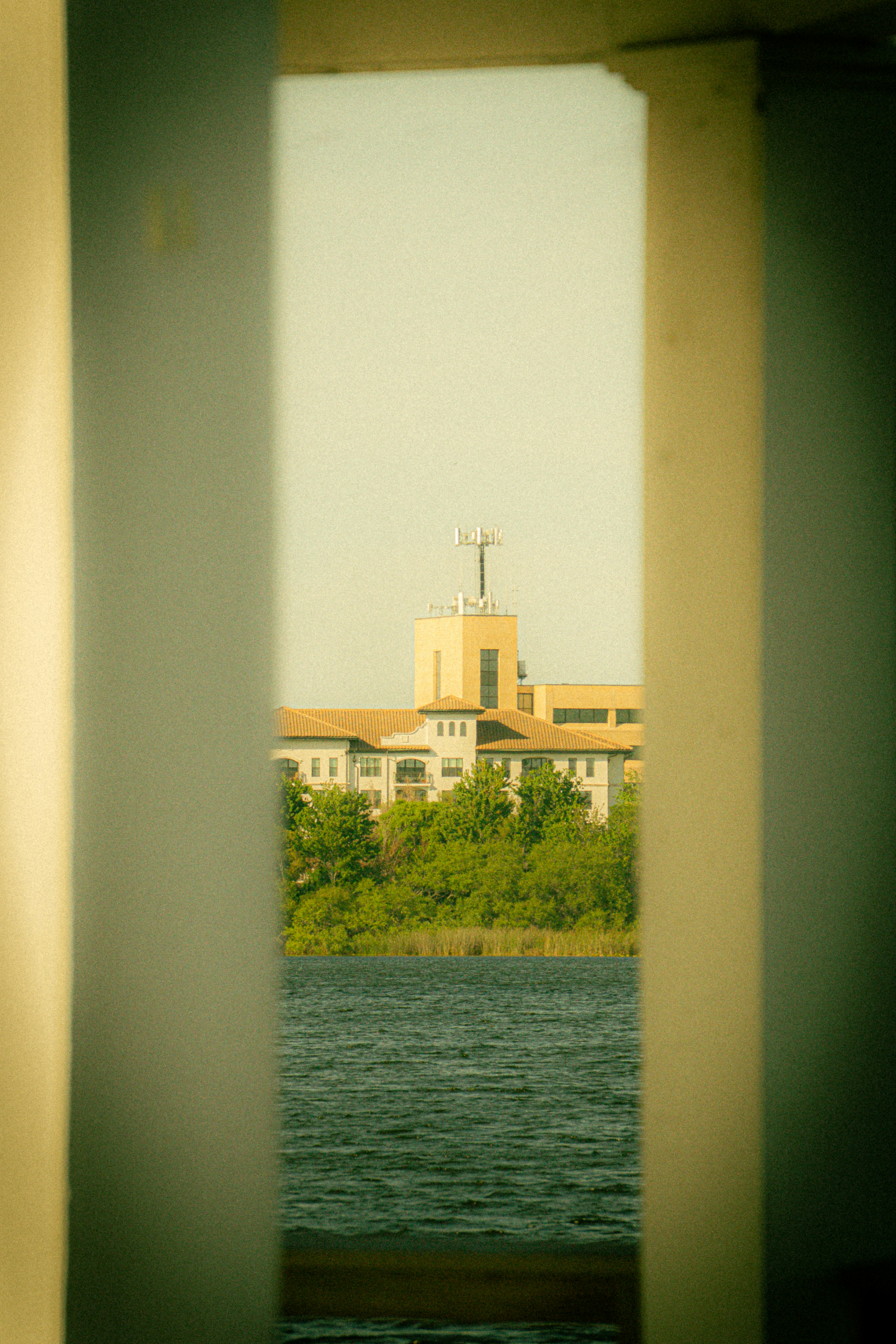 Building by the water with trees and sky